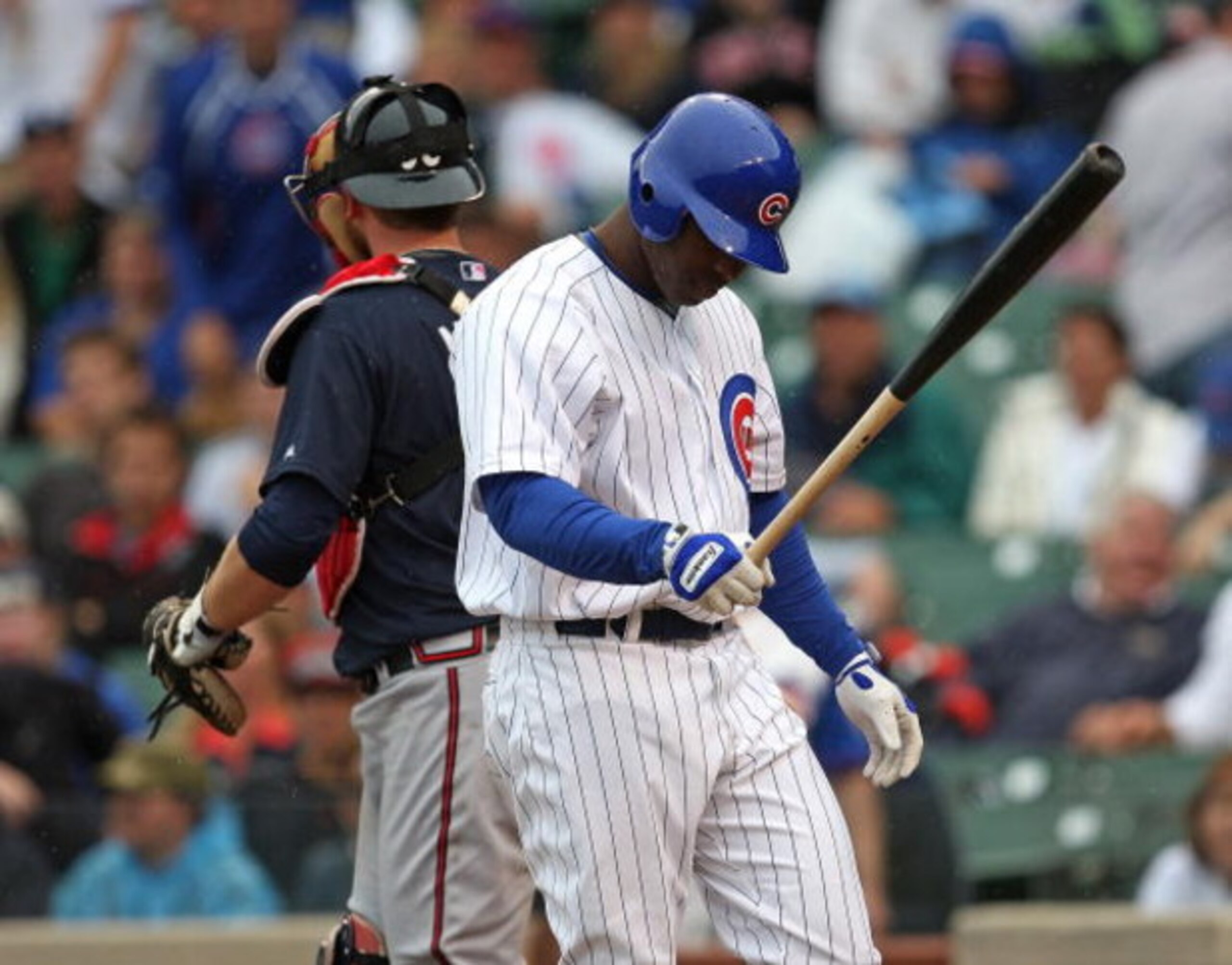 CHICAGO - JULY 08: Milton Bradley #21 of the Chicago Cubs walks back to the dugout after making the final out of the game as Brian McCann #16 of the Atlanta Braves walks to the mound on July 8, 2009 at Wrigley Field in Chicago, Illinois. The Braves defeat