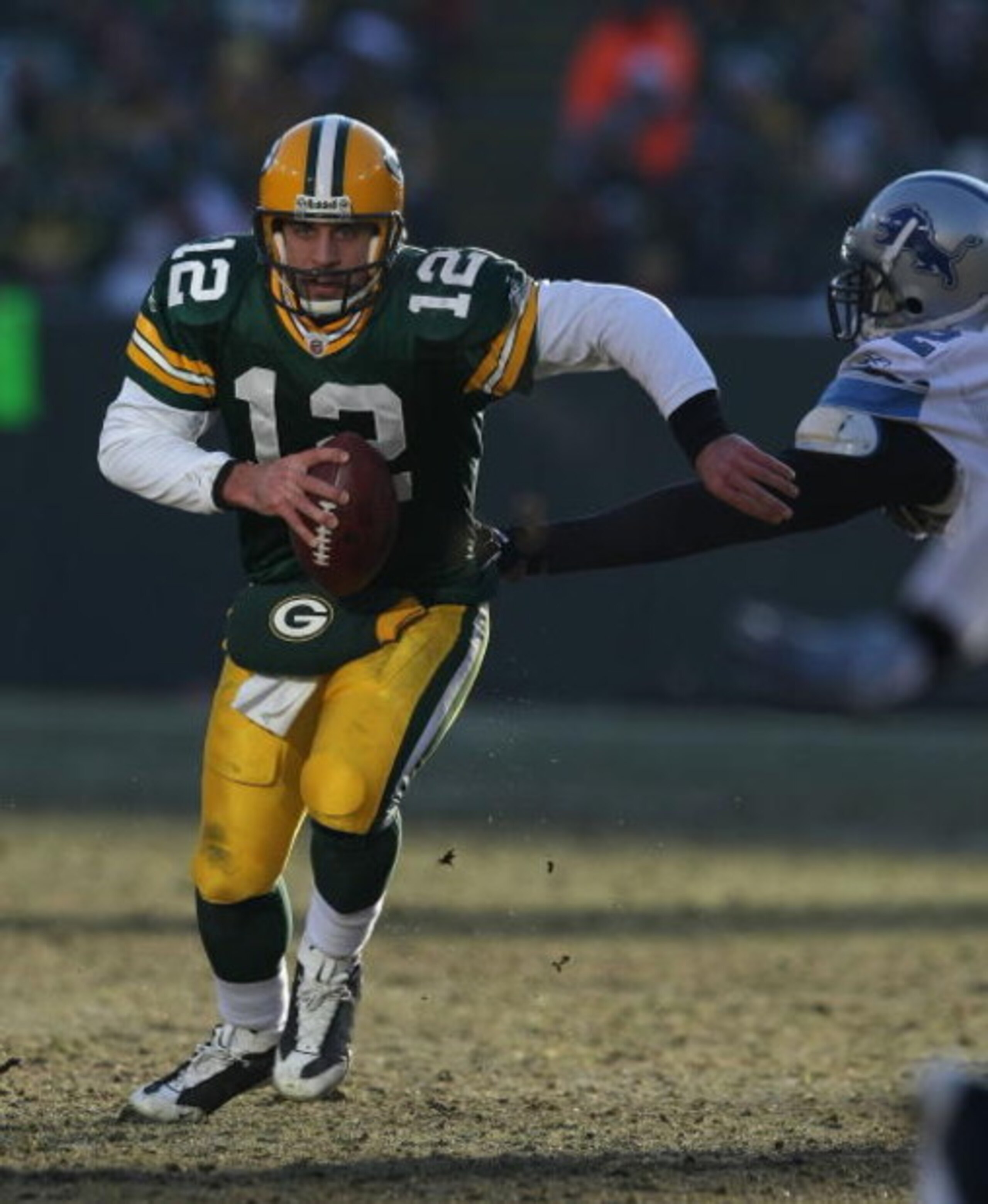 GREEN BAY, WI - DECEMBER 28: Aaron Rodgers #12 of the Green Bay Packers breaks away from Cliff Avril #92 of the Detroit Lions on December 28, 2008 at Lambeau Field in Green Bay, Wisconsin. The Packers defeated the Lions 31-21. (Photo by Jonathan Daniel/Ge
