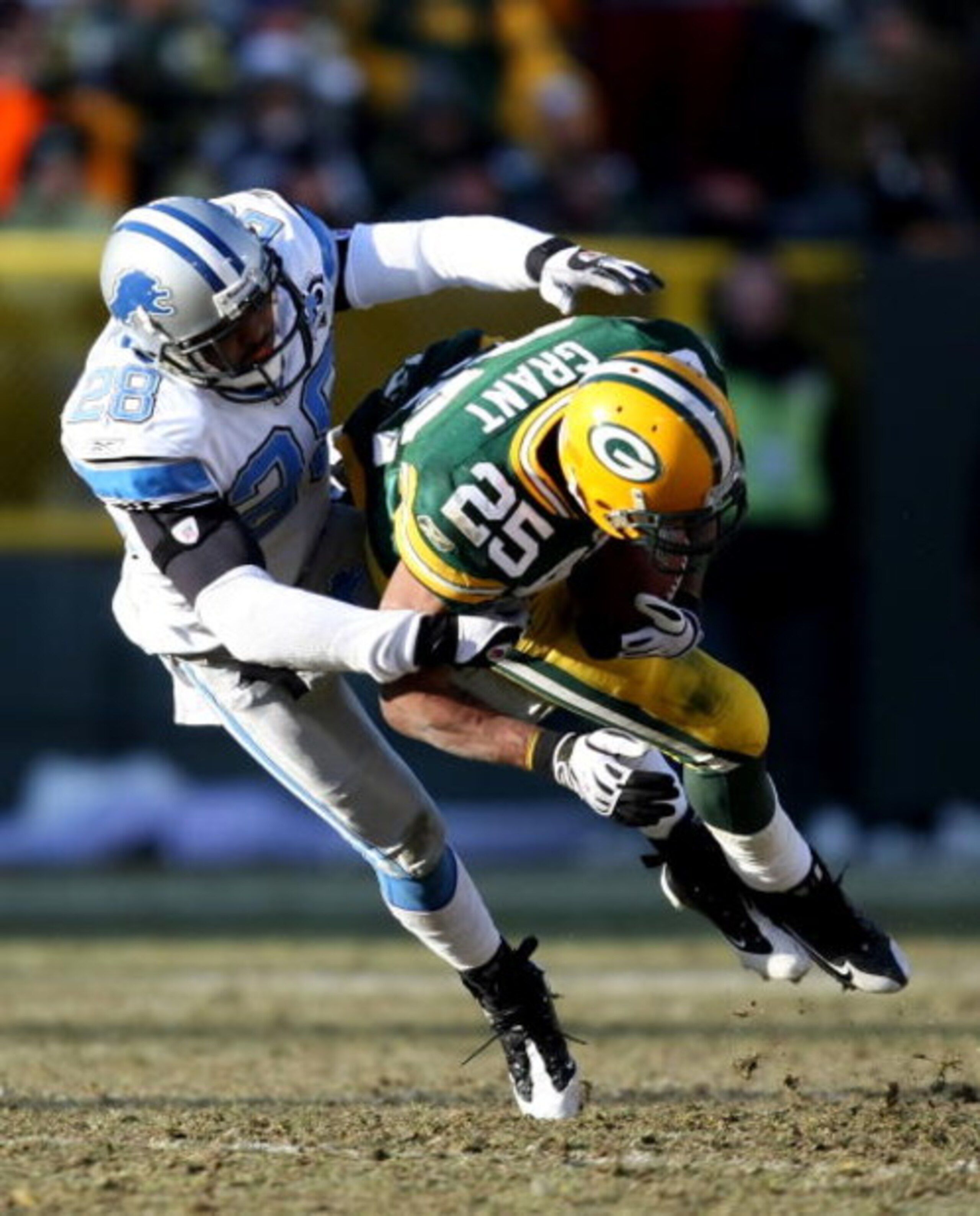 GREEN BAY, WI - DECEMBER 28: Ryan Grant #25 of the Green Bay Packers is pulled down by Leigh Bodden #28 of the Detroit Lions on December 28, 2008 at Lambeau Field in Green Bay, Wisconsin. The Packers defeated the Lions 31-21. (Photo by Jonathan Daniel/Get