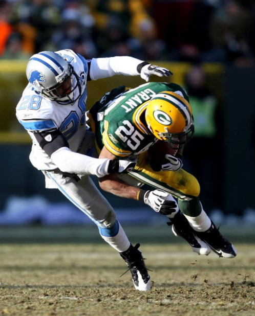GREEN BAY, WI - DECEMBER 28: Ryan Grant #25 of the Green Bay Packers is pulled down by Leigh Bodden #28 of the Detroit Lions on December 28, 2008 at Lambeau Field in Green Bay, Wisconsin. The Packers defeated the Lions 31-21. (Photo by Jonathan Daniel/Get