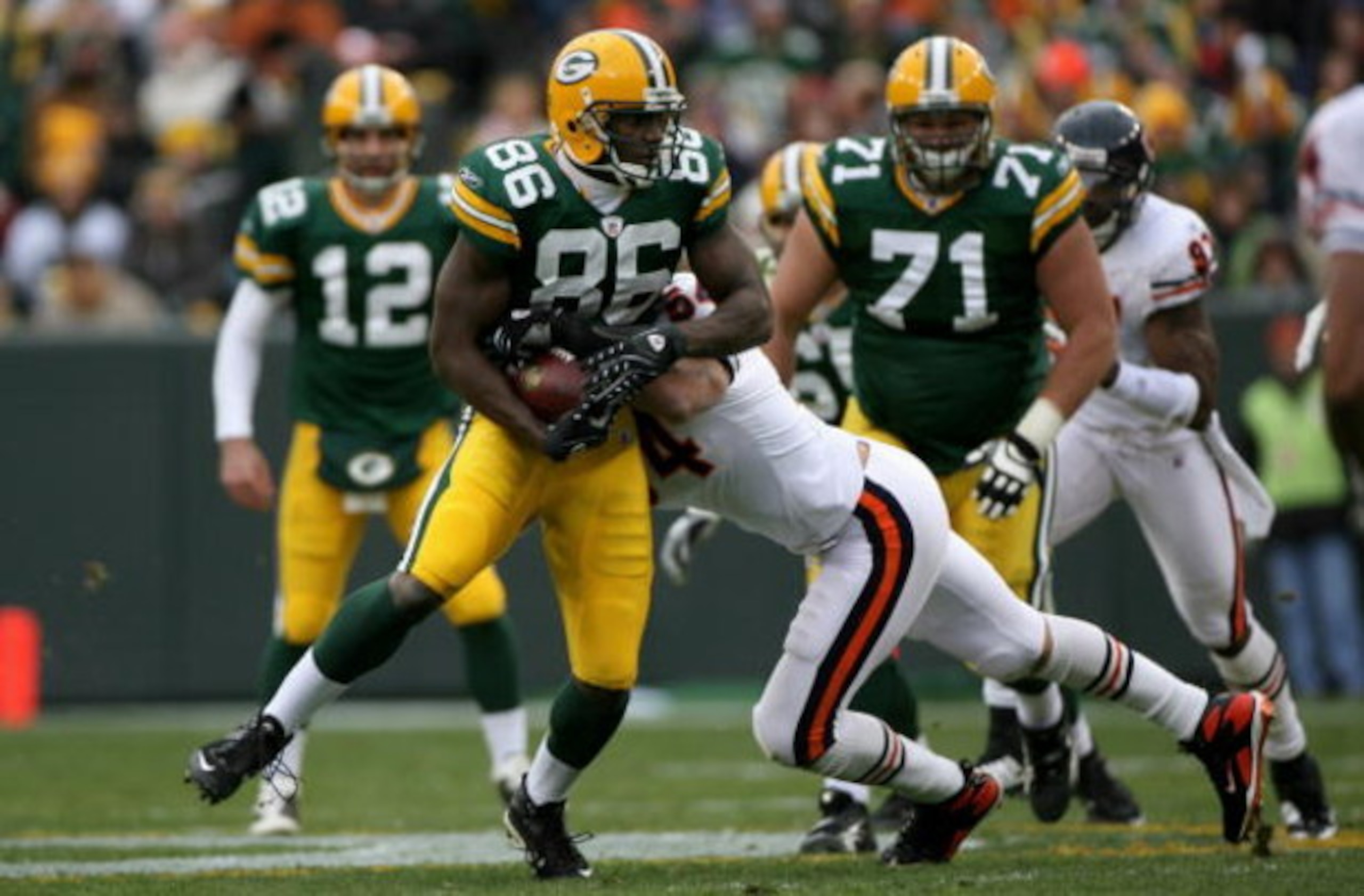 GREEN BAY, WI - NOVEMBER 16:  Tight end Donald Lee #86 of the Green Bay Packers makes a third down reception and is stopped short of the first down by linebacker Brian Urlacher #54 of the Chicago Bears during the NFL game at Lambeau Field on November 16, 