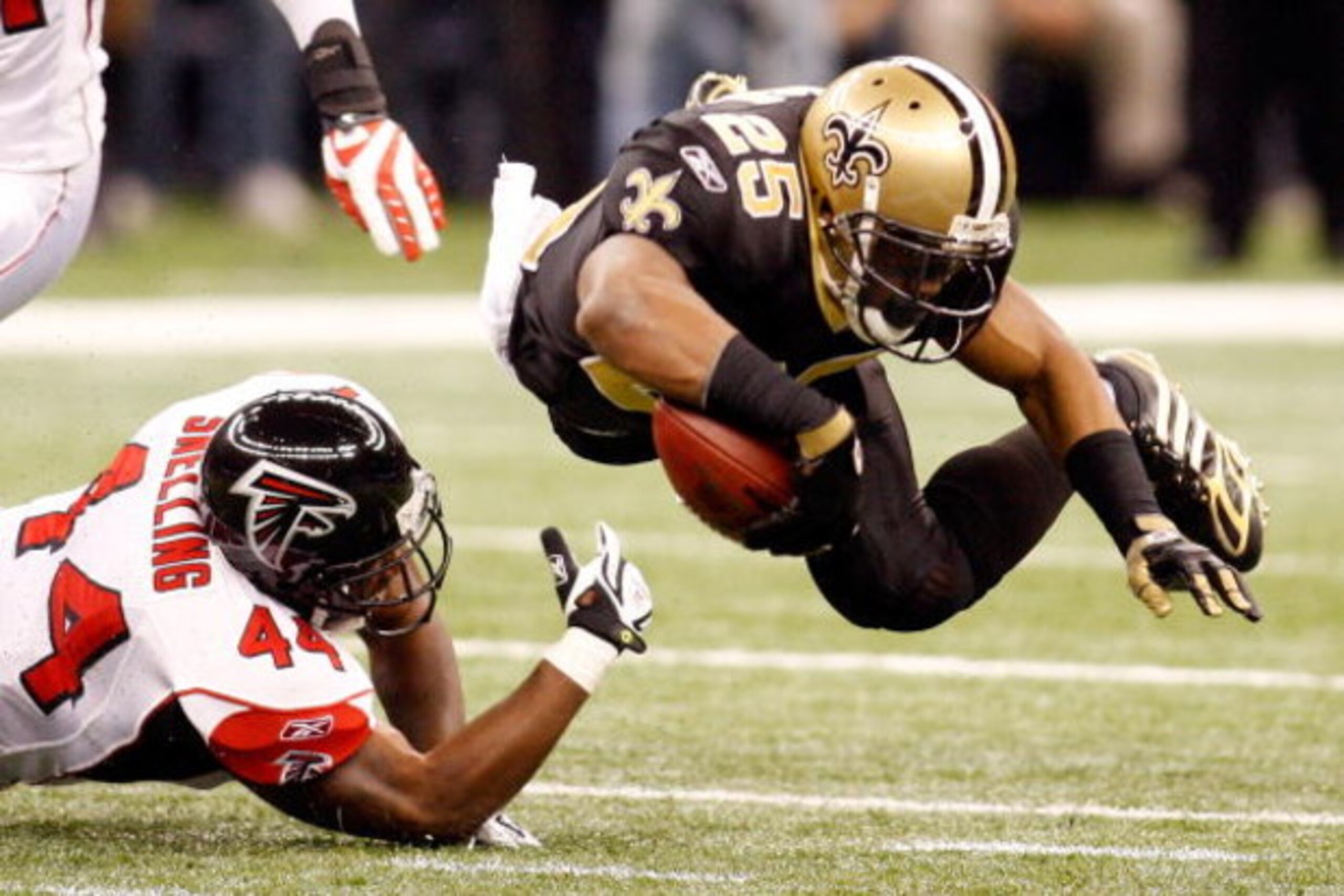 NEW ORLEANS - DECEMBER 07:  Reggie Bush #25 of the New Orleans Saints is tripped by Jason Snelling #44 of the Atlanta Falcons on December 7, 2008 at the Superdome in New Orleans, Louisiana.  (Photo by Chris Graythen/Getty Images)