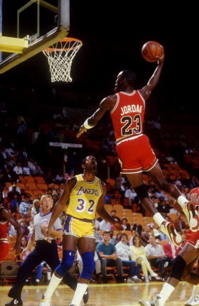 1980's:  CHICAGO GUARD MICHAEL JORDAN FLIES TO THE BASKET FOR A DUNK OVER LOS ANGELES GUARD MAGIC JOHNSON DURING THE BULLS GAME VERSUS THE BULLS AT THE GREAT WESTERN FORUM IN LOS ANGLELES, CALIFORNIA. Mandatory Credit: Rick Stewart/ALLSPORT