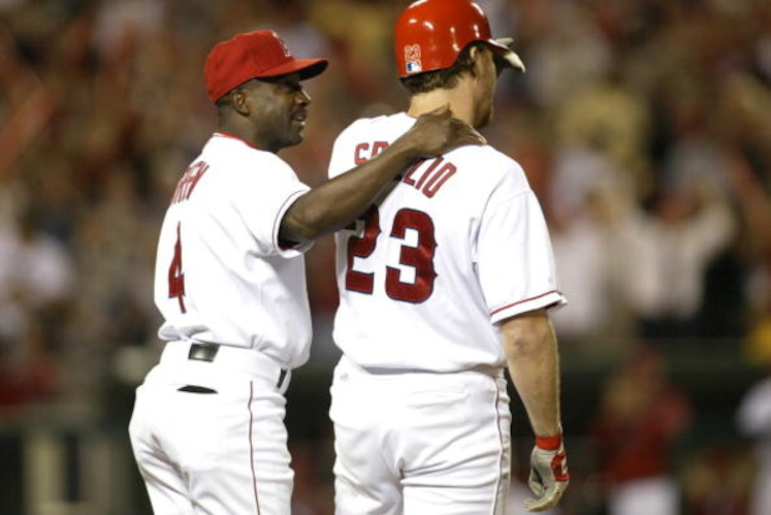 ANAHEIM, CA - OCTOBER 4:  First base coach Alfredo Griffin #4 of the Anaheim Angels talks with Scott Spiezio #23 as he stands on the bag during game 3 of the American League Divisional Series against the New York Yankees on October 4, 2002 at Edison Field