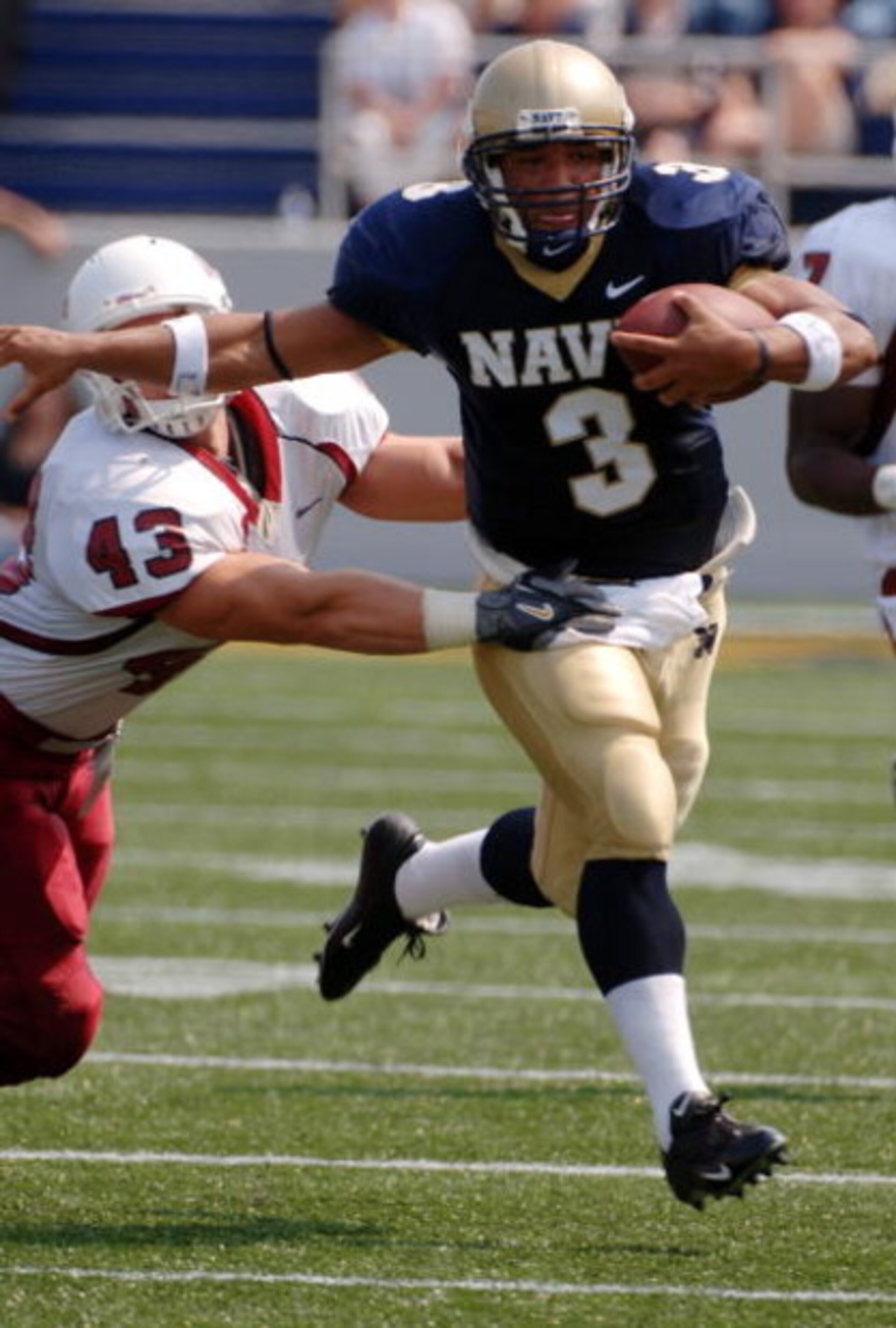 ANNAPOLIS, MD - SEPTEMBER 9:  In this handout provided by the U.S. Navy, Quarterback Brian Hampton of the Navy Midshipmen outpaces linebacker Jason Hatchell of the Massachusetts Minutemen in the first half of play on September 9, 2006 at Navy Memorial Sta