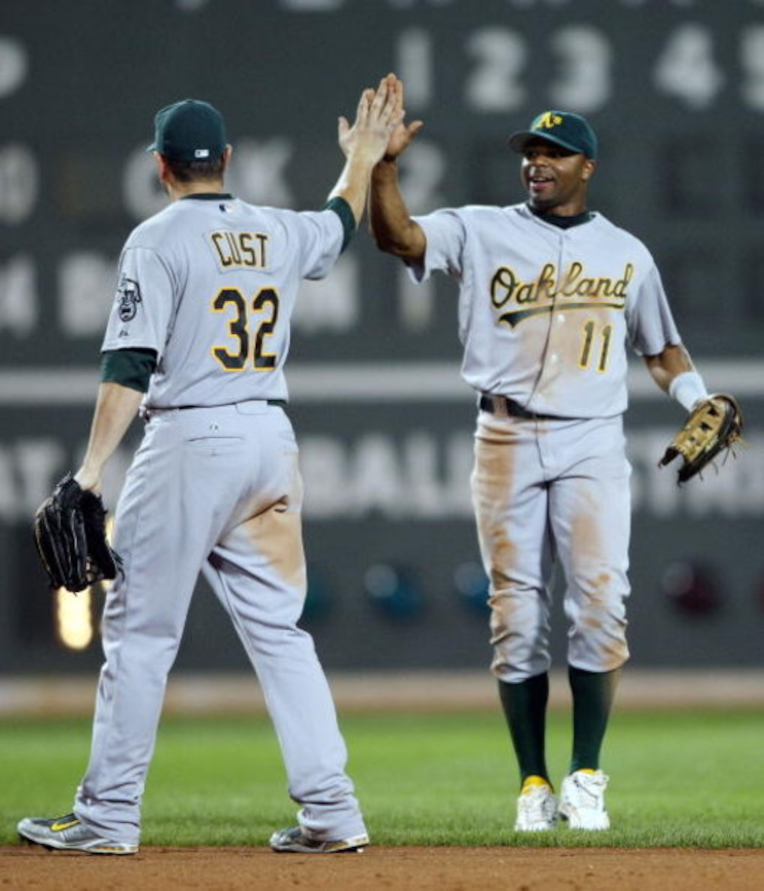 BOSTON - JULY 28:  Rajai Davis #11 of the Oakland Athletics celebrates the win with Jack Cust #32 after defeated the Boston Red Sox 9-8 in 11 innings at Fenway Park July 28, 2009 in Boston, Massachusetts. (Photo by Elsa/Getty Images)