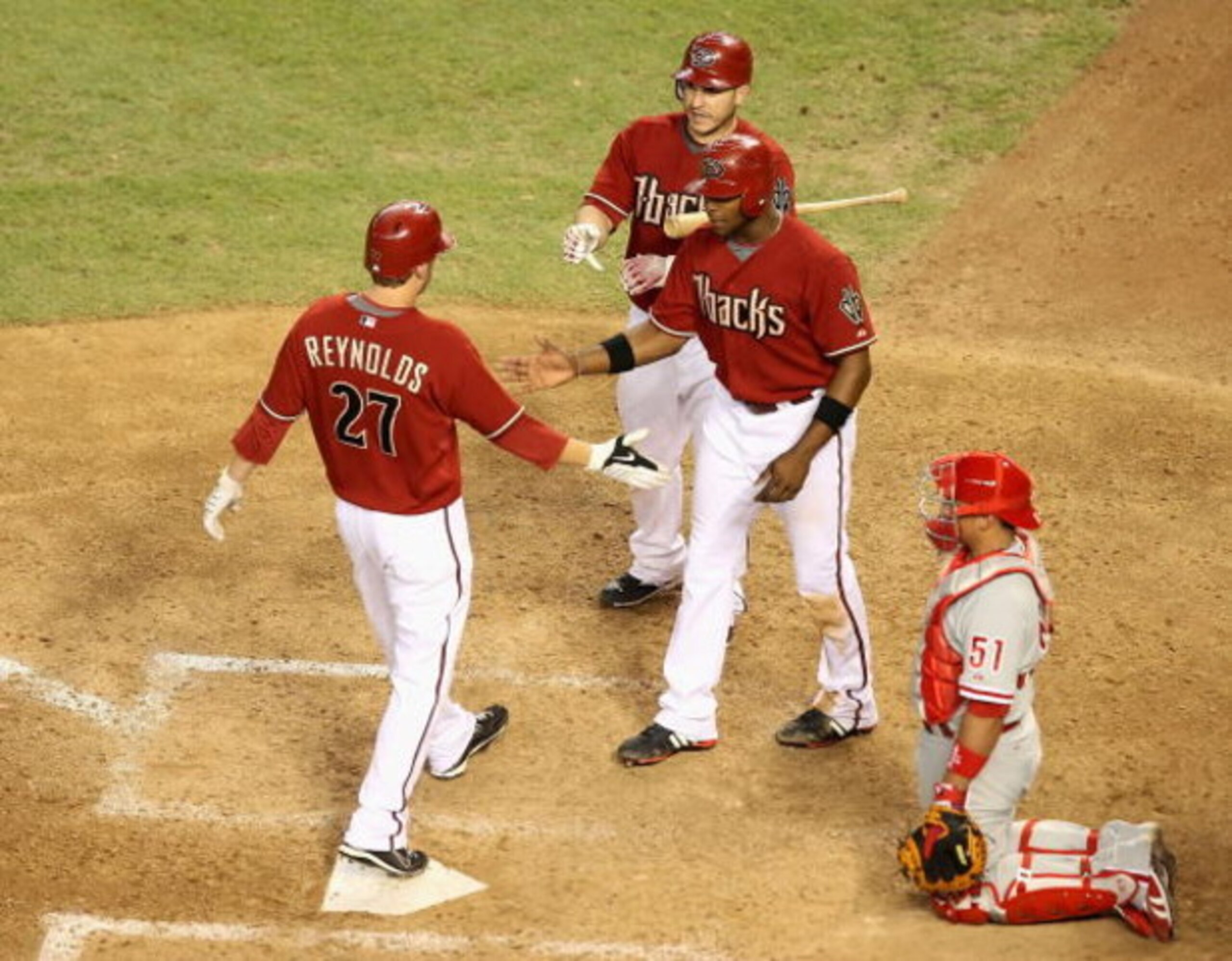 PHOENIX - JULY 28:  Mark Reynolds #27 of the Arizona Diamondbacks is congratulated by teammates Justin Upton #10 and Miguel Montero #26 after hitting a 2 run home run against the Philadelphia Phillies during the ninth inning of the major league baseball g
