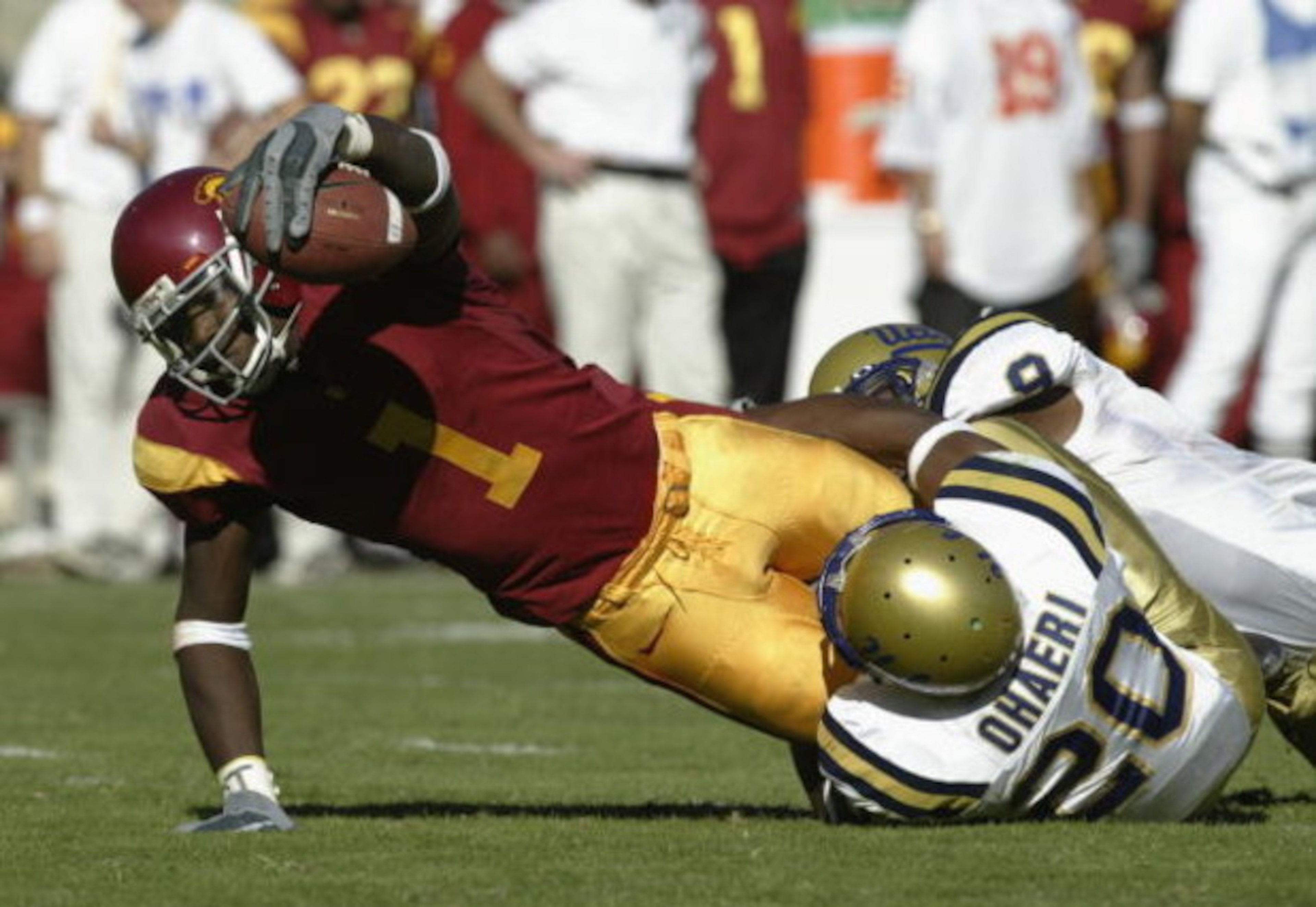 LOS ANGELES - NOVEMBER 22:  Mike Williams #1 of USC stretches after the catch as he is tackled by Glenn Ohaeri #20 of UCLA during the game at the Los Angeles Memorial Coliseum on November 22, 2003 in Los Angeles, California.  USC defeated UCLA 47-22.  (Ph