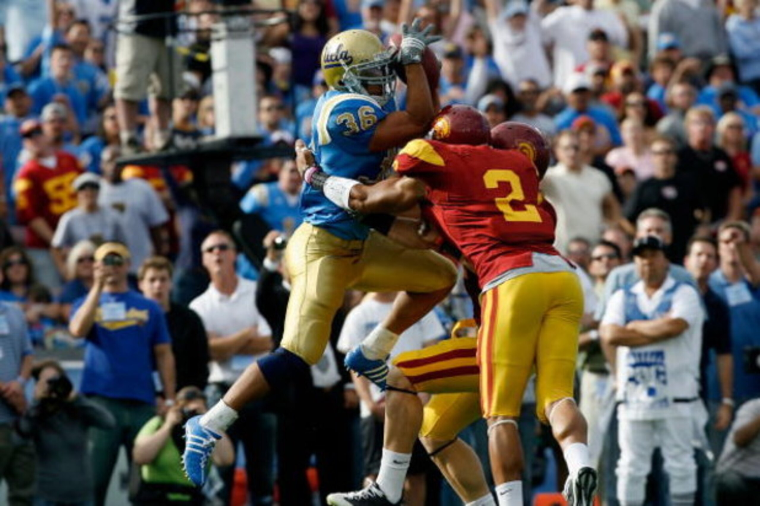 PASADENA, CA - DECEMBER 06:  Kahlil Bell #36 of the UCLA Bruins catches a pass for touchdown over Clay Matthews #47 and Taylor Mays #2 of the USC Trojans in the first quarter on December 6, 2008 at the Rose Bowl in Pasadena, California.  (Photo by Harry H