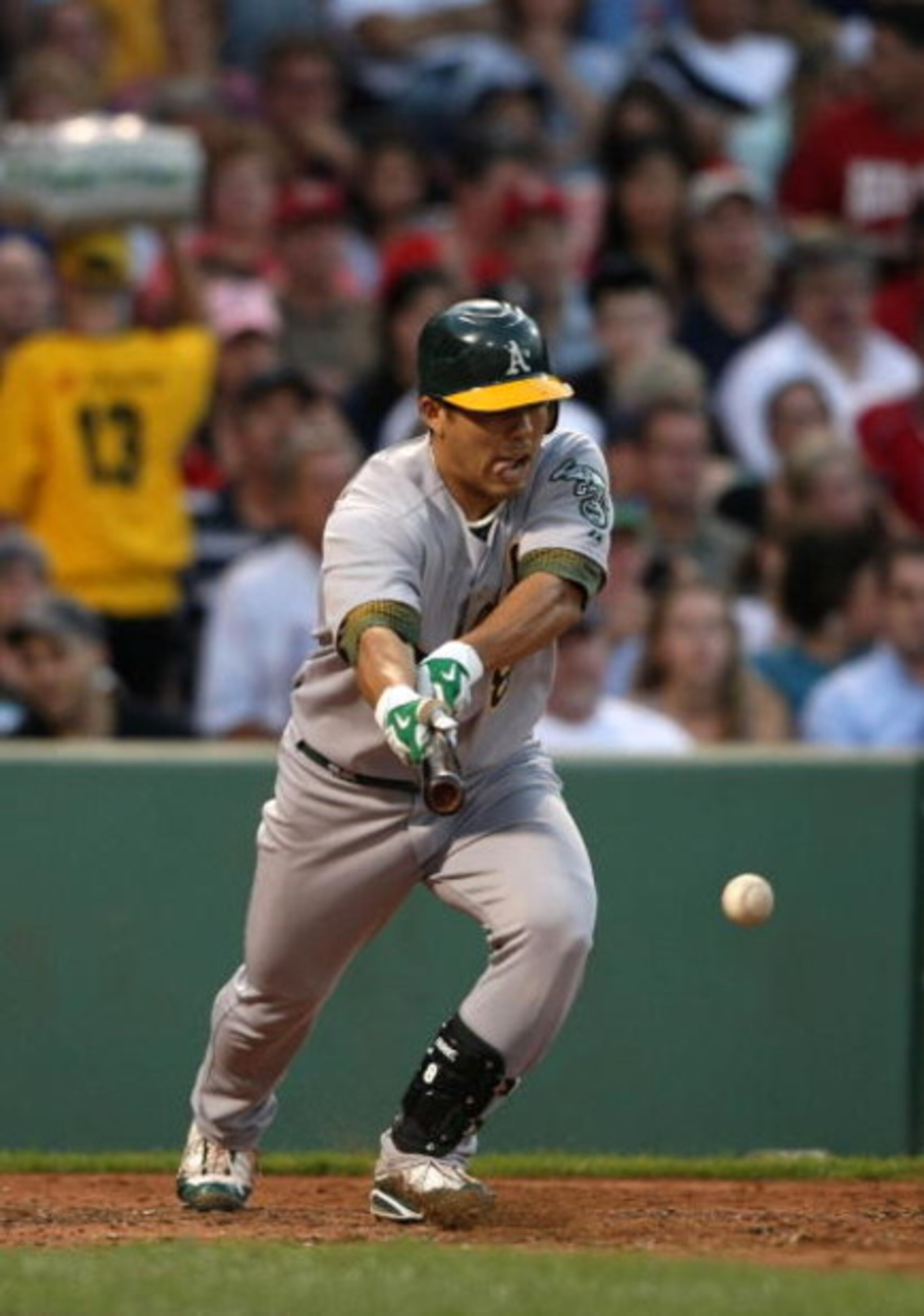 BOSTON - JULY 06:  Kurt Suzuki #8 of the Oakland Athletics lays down a bunt against the Boston Red Sox at Fenway Park on July 6, 2009 in Boston, Massachusetts. (Photo by Elsa/Getty Images)