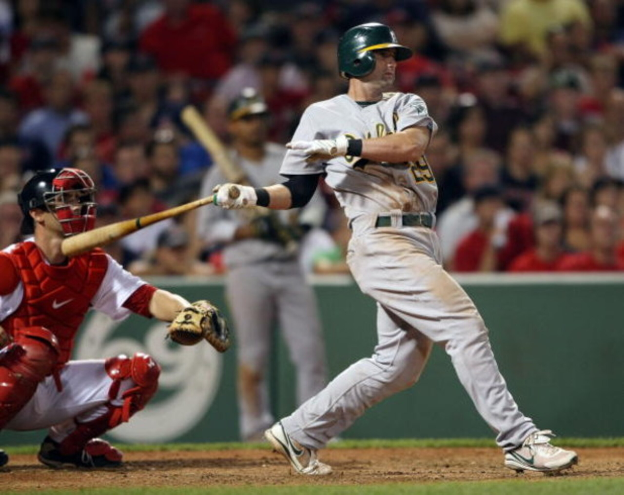 BOSTON - JULY 28:  Adam Kennedy #29 of the Oakland Athletics drives in the game-winning run in the 11th inning as catcher George Kottaras #16 of the Boston Red Sox defends at Fenway Park July 28, 2009 in Boston, Massachusetts. The A's defeated the Red Sox