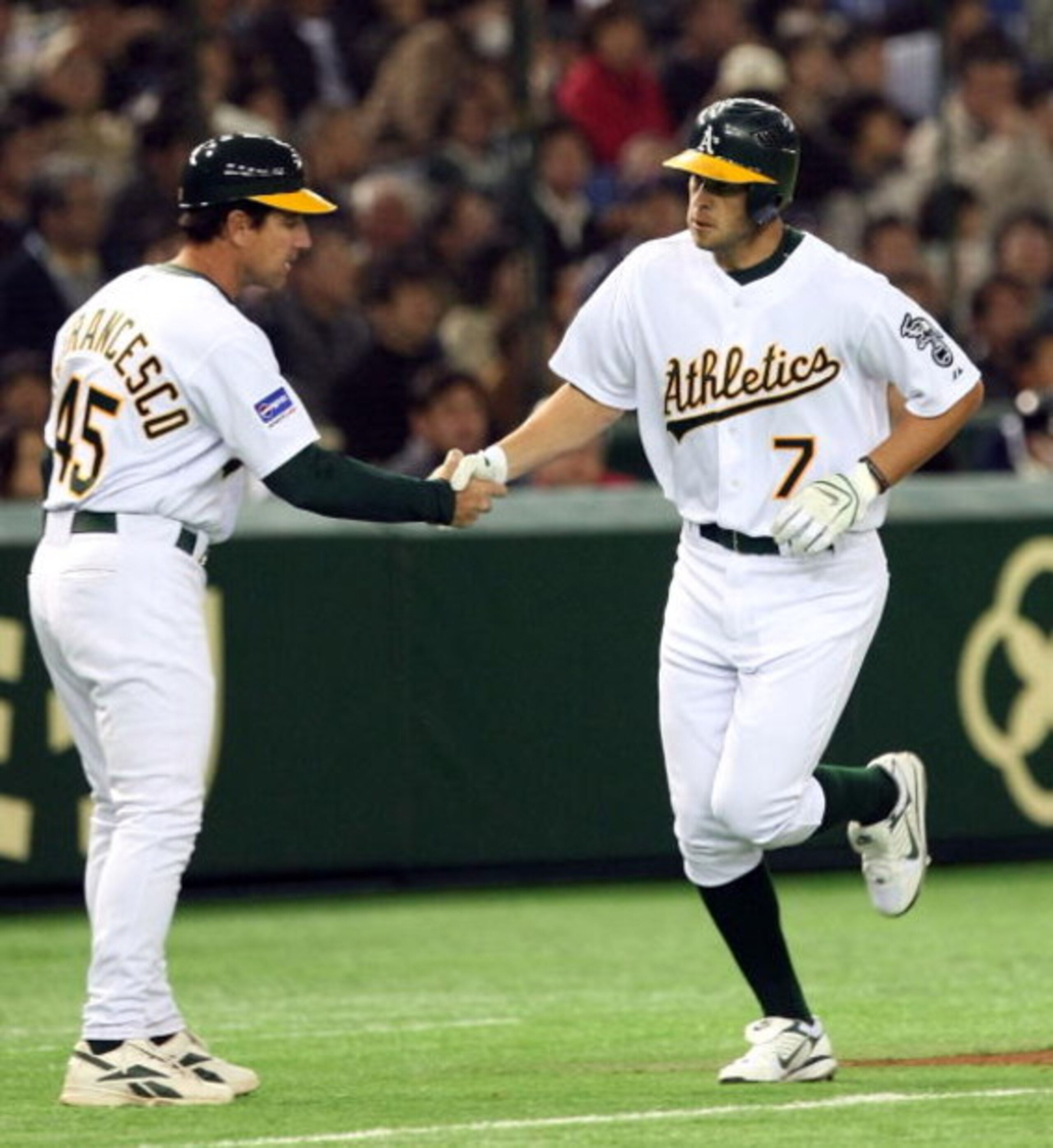 TOKYO - MARCH 22:  Infielder Bobby Crosby #7 of Oakland Athletics shakes hands with coach Tony DeFrancesco #45 after his home run during preseason friendly game between Oakland Athletics and Yomiuri Giants at Tokyo Dome on March 22, 2008 in Tokyo, Japan. 