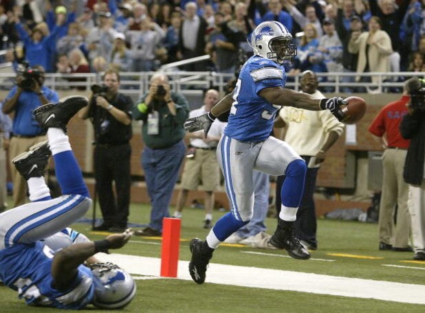 DETROIT - OCTOBER 16:  Boss Bailey #97 of the Detroit Lions scores a touchdown after intercepting a pass against the Carolina Panthers on October 16, 2005 at Ford Field in Detroit, Michigan.  (Photo by Tom Pidgeon/Getty Images)
