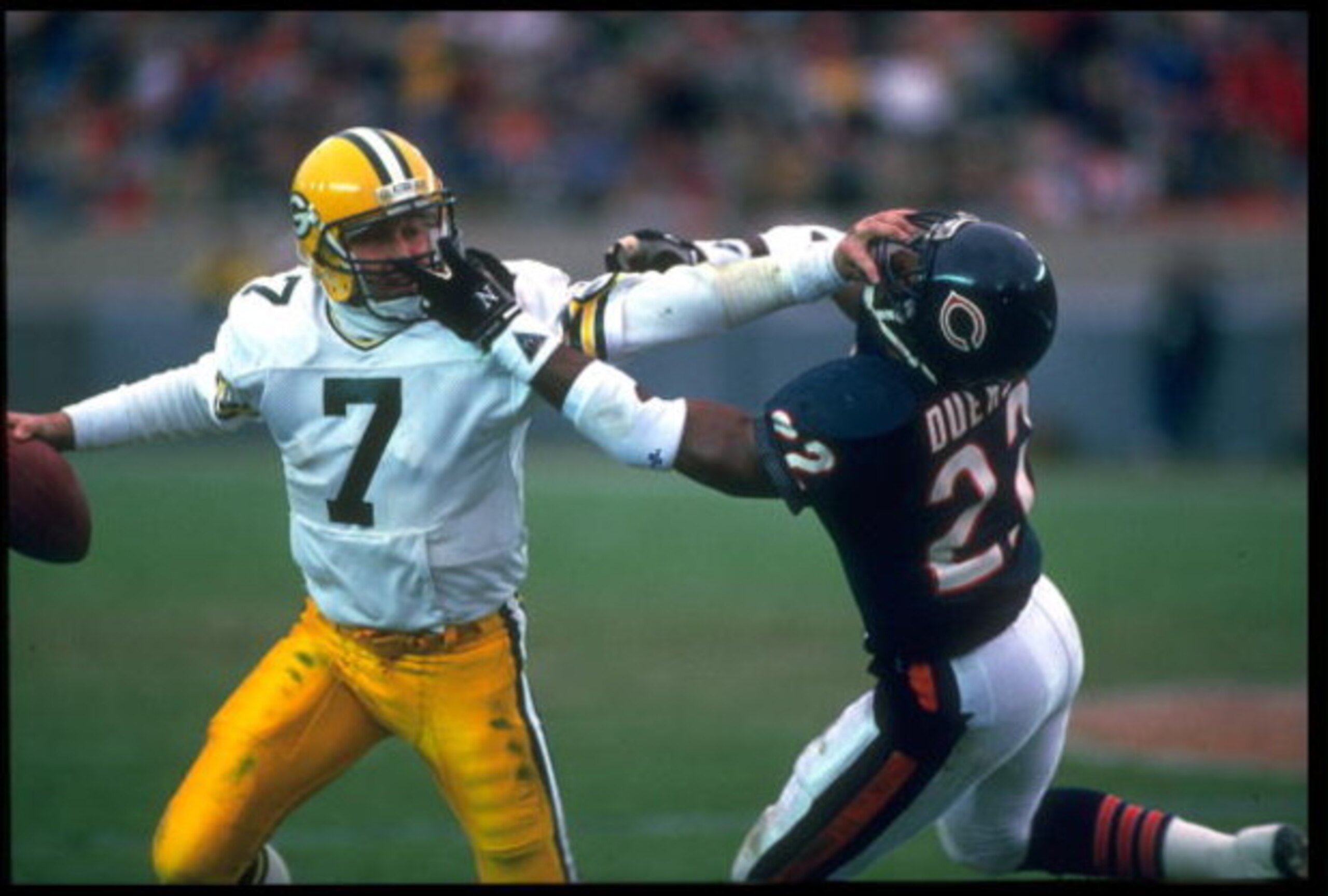 27 Nov 1988: GREEN BAY PACKERS QUARTERBACK DAN MAJKOWSKI (LEFT) GIVES A STIFF ARM TO AN UNIDENTIFIED CHICAGO BEARS DEFENDER DURING THE PACKERS 16-0 LOSS AT SOLDIER FIELD IN CHICAGO, ILLINOIS.