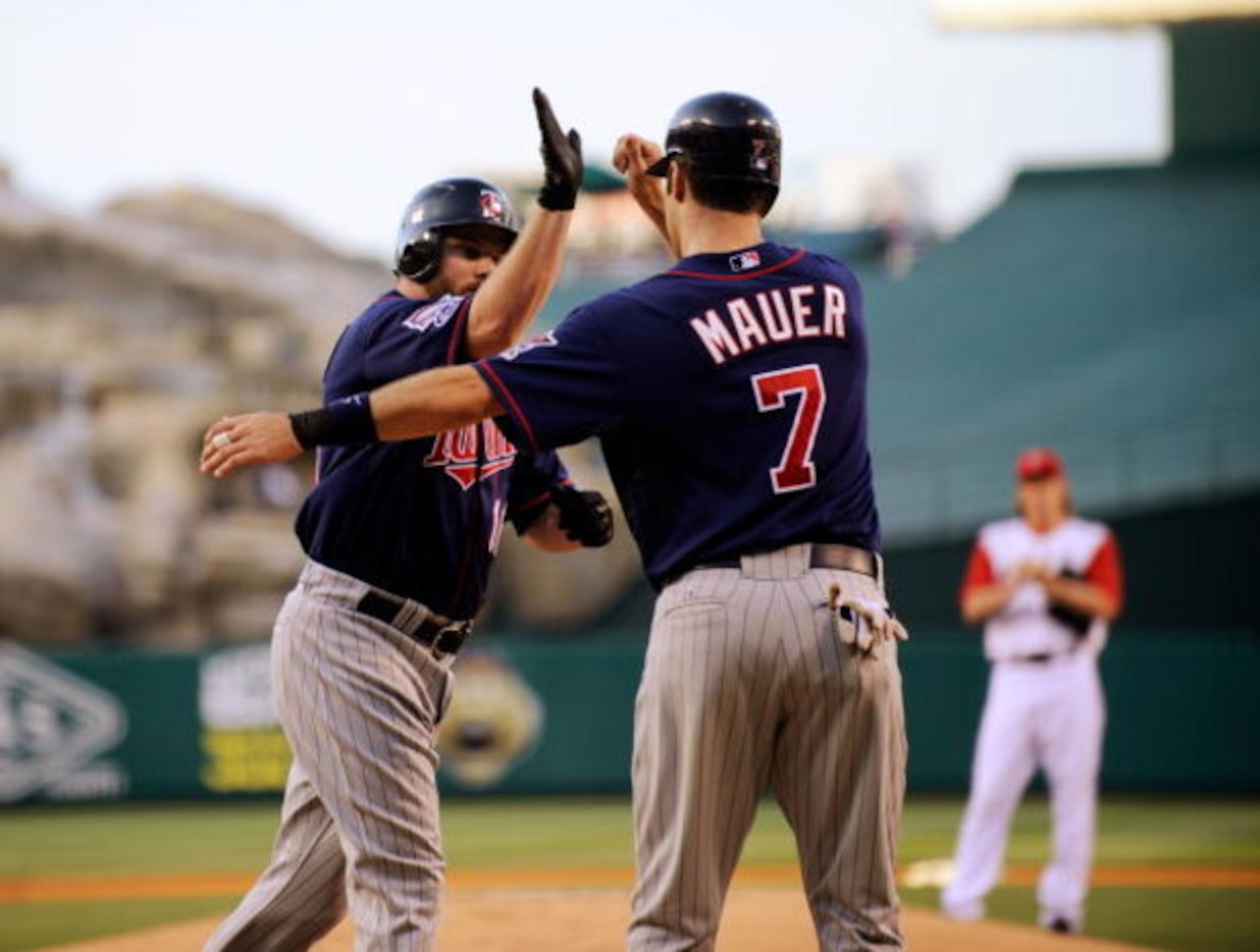 ANAHEIM, CA - JULY 23:  Jason Kubel #16 of the Minnesotta Twins is congratulated by teammate Joe Maur #7 after hitting a two-run home run off pitcher Jered Weaver #36 of the Los Angeles Angels of Anaheim during the first inning of the baseball game on Jul