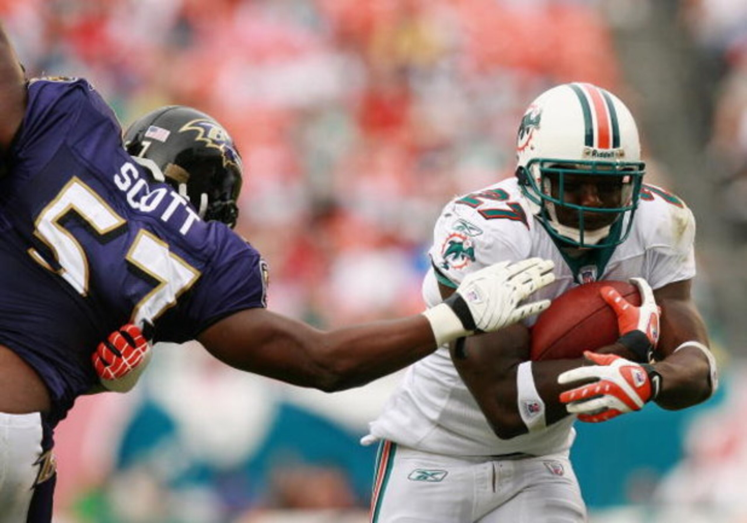MIAMI - DECEMBER 16:  Running back Samkon Gado #27 of the Miami Dolphins tries to avoid linebacker Bart Scott #57 of the Baltimore Ravens at Dolphin Stadium on December 16, 2007 in Miami, Florida. The Dolphins defeated the Ravens 22-16 for their first vic