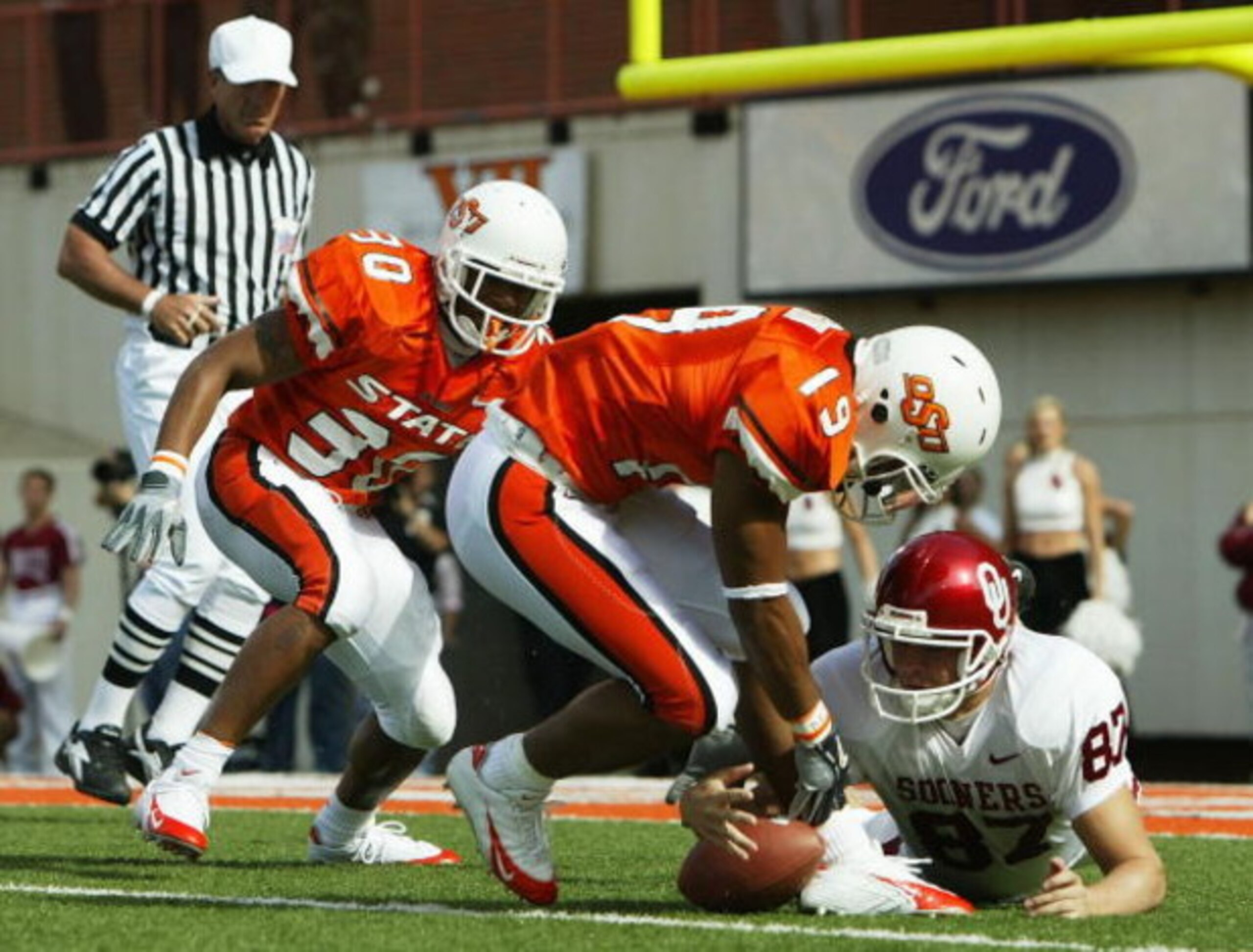 STILLWATER, OK - OCTOBER 30:  Punter Blake Ferguson #87 (R) of Oklahoma scrambles for the ball along with safety Jeremy Nethon #19 and safety Grant Jones #30 of Oklahoma State in the second quarter at Boone Pickens Stadium on October 30, 2004 in Stillwate