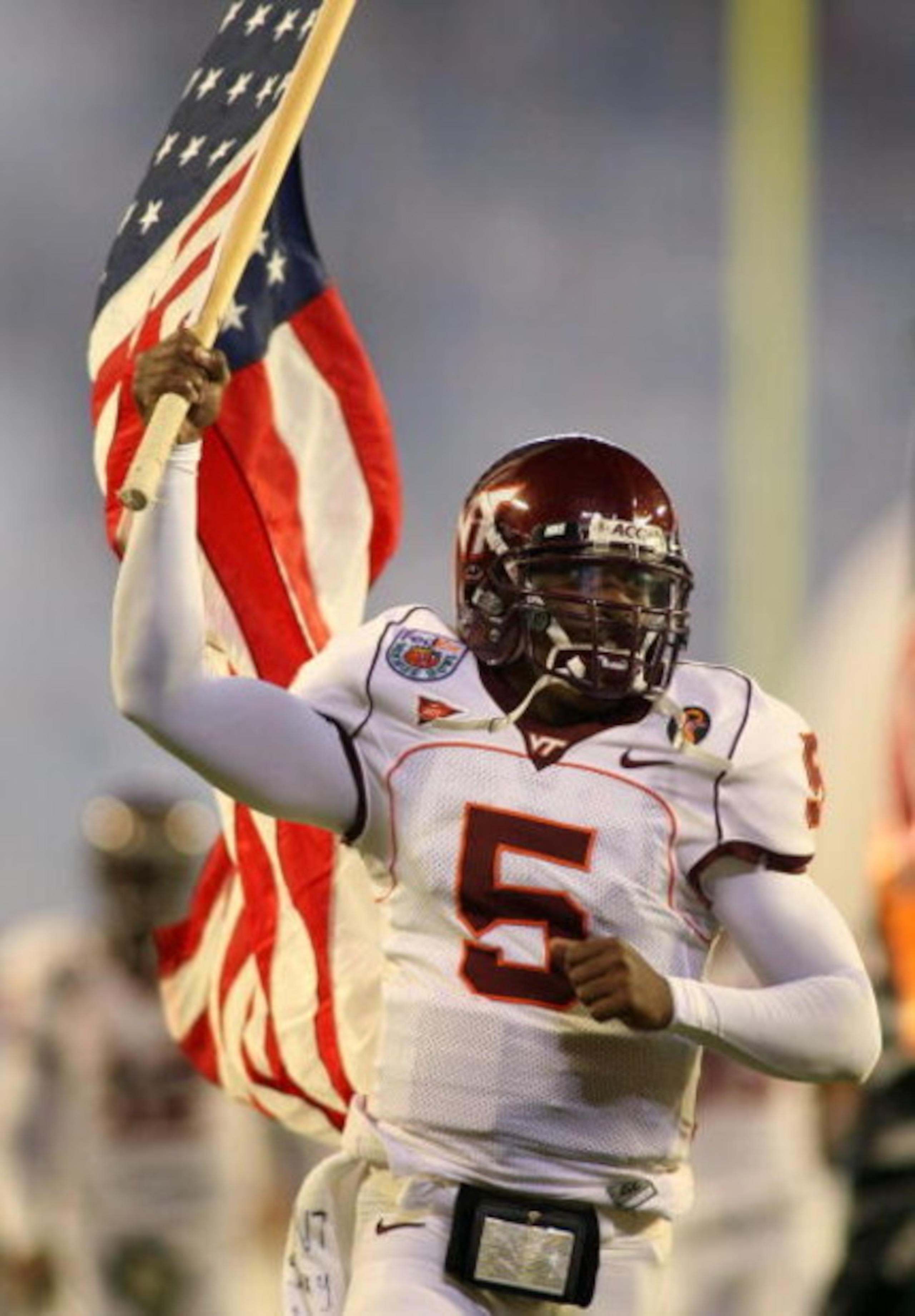 MIAMI - JANUARY 03:  Quarterback Tyrod Taylor #5 of the Virginia Tech Hokies runs on to the field holding the American flag before taking on the Kansas Jayhawks in the FedEx Orange Bowl at Dolphin Stadium on January 3, 2008 in Miami, Florida.  (Photo by M