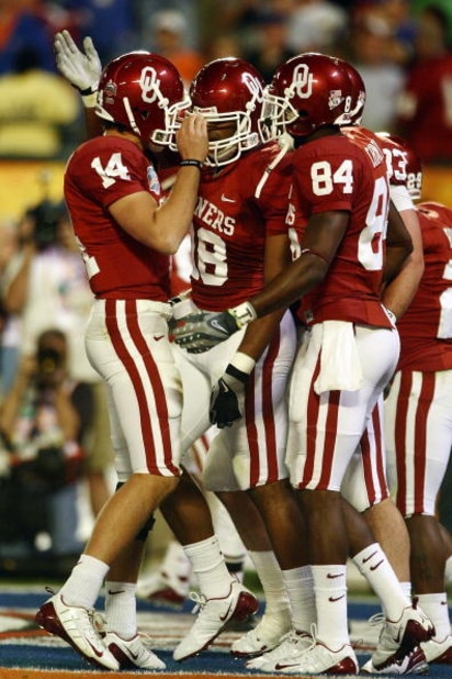 MIAMI - JANUARY 08:  Sam Bradford #14 of the Oklahoma Sooners celebrates with teammates Jermaine Gresham #18 and Quentin Chaney #84 after scoring a touchdown againist the Florida Gators during the FedEx BCS National Championship Game at Dolphin Stadium on