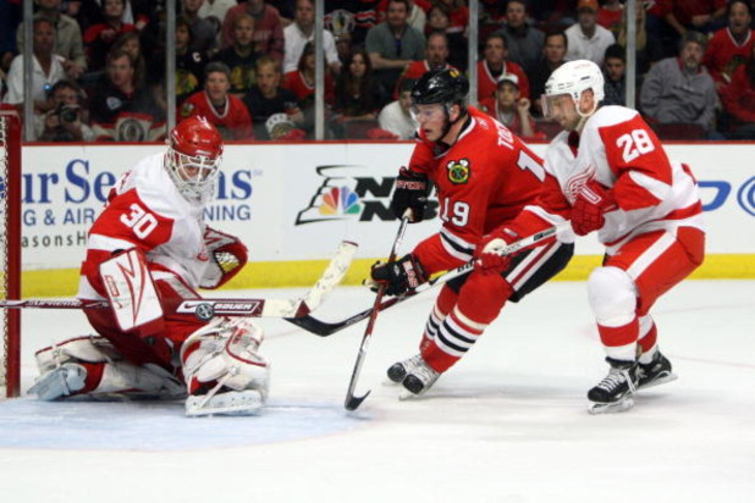 CHICAGO - MAY 24:  Goalie Chris Osgood #30 of the Detroit Red Wings makes a save on a shot attempt by Jonathan Toews #19 of the Chicago Blackhawks as Brian Rafalski #28 of the Red WIngs trails on the play during the first period of Game Four of the Wester