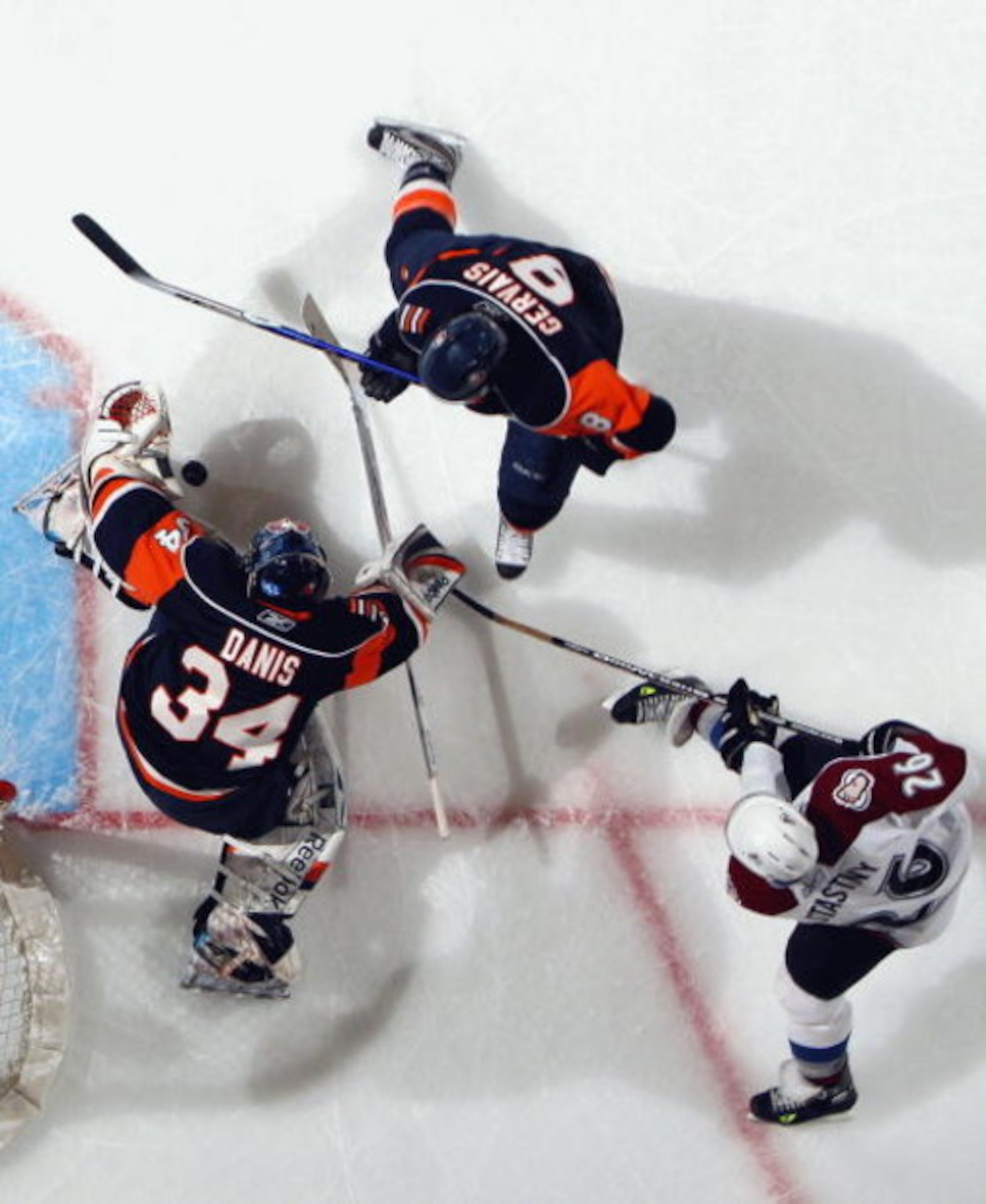 UNIONDALE, NY - MARCH 02:  Paul Stastny #26 of the Colorado Avalanche battles for the puck against Bruno Gervais #8 and Yann Danis #34 of the New York Islanders on March 2, 2009 at Nassau Coliseum in Uniondale, New York. The Isles defeated the Avalanche 4