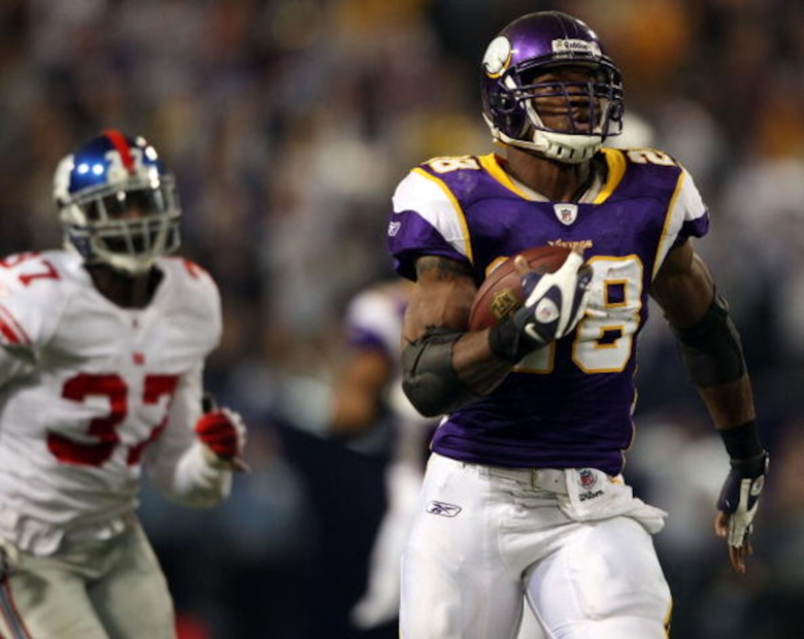 MINNEAPOLIS - DECEMBER 28:  Adrian Peterson #28 of the Minnesota Vikings carries the ball in for a touchdown as James Butler #37 of the New York Giants defends on December 28, 2008 at the Hubert H. Humphrey Metrodome in Minneapolis, Minnesota. (Photo by E