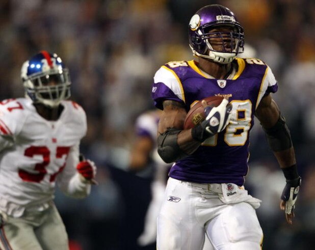 MINNEAPOLIS - DECEMBER 28:  Adrian Peterson #28 of the Minnesota Vikings carries the ball in for a touchdown as James Butler #37 of the New York Giants defends on December 28, 2008 at the Hubert H. Humphrey Metrodome in Minneapolis, Minnesota. (Photo by E