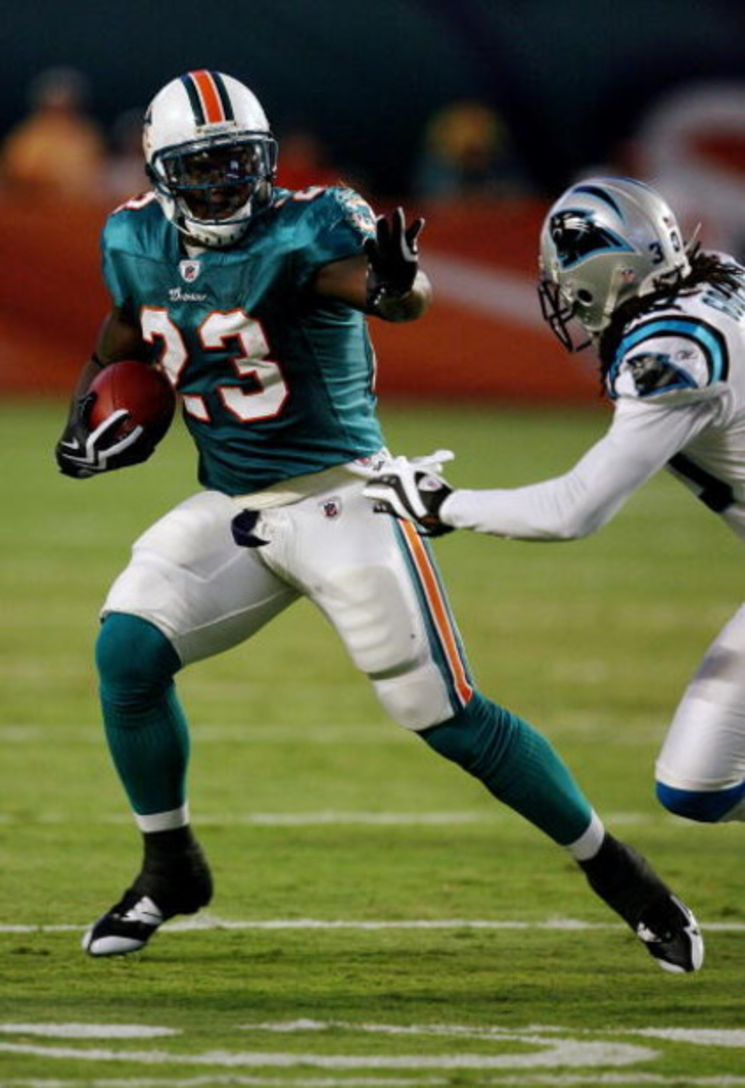 MIAMI - AUGUST 22:  Running back Ronnie Brown #23 of the Miami Dolphins tries to avoid a tackle attempt by Charles Godfrey #30 of the Carolina Panthers during a pre-season game at Land Shark Stadium on August 22, 2009 in Miami, Florida.  (Photo by Doug Be