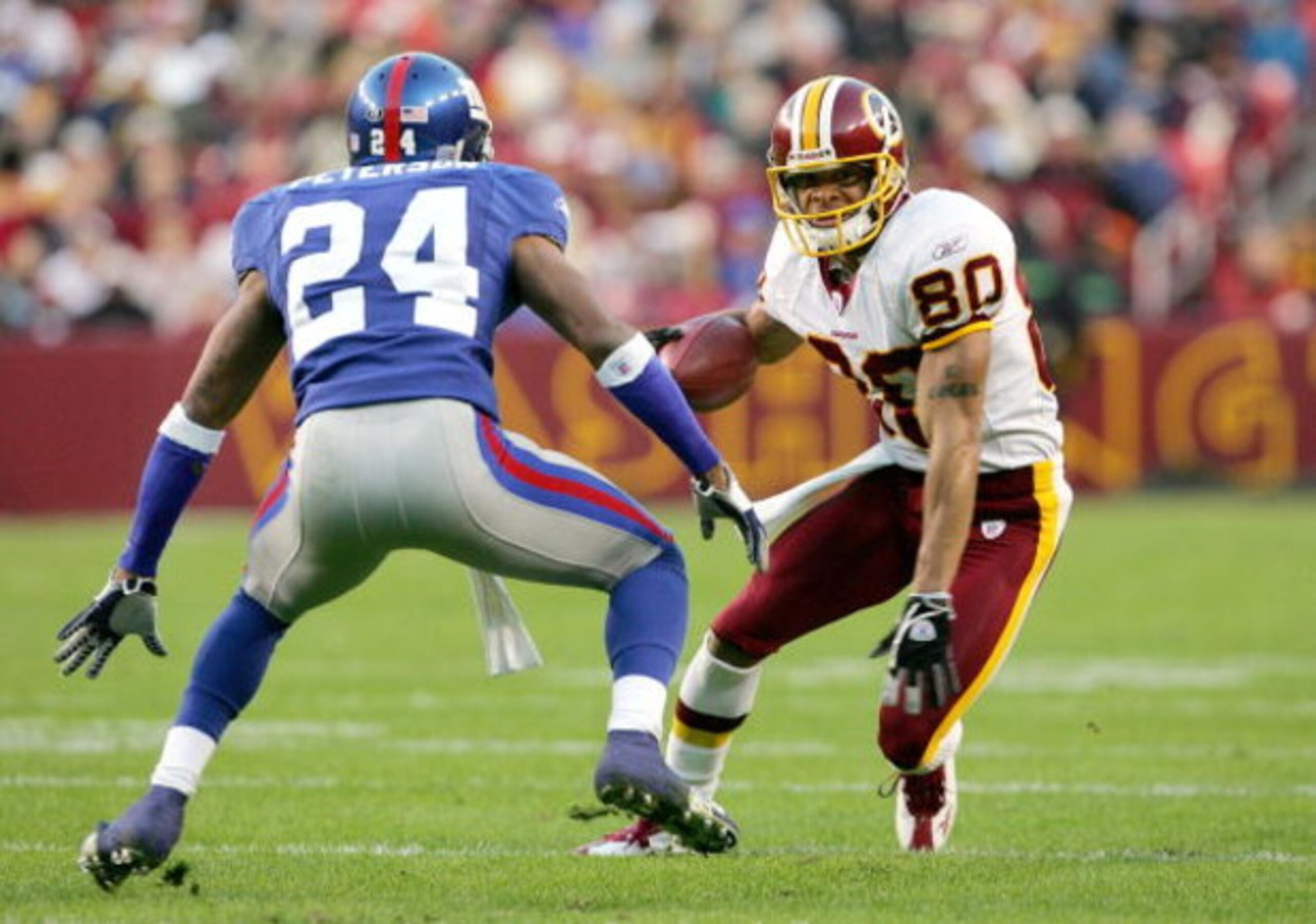 LANDOVER, MD - DECEMBER 5: Receiver Laveraneus Coles #80 of the Washington Redskins makes a reception as Will Peterson #24 of the New York Giants defends during the first half of the game at Fed Ex Field on December 5, 2004 in Landover, Maryland.  (Photo 