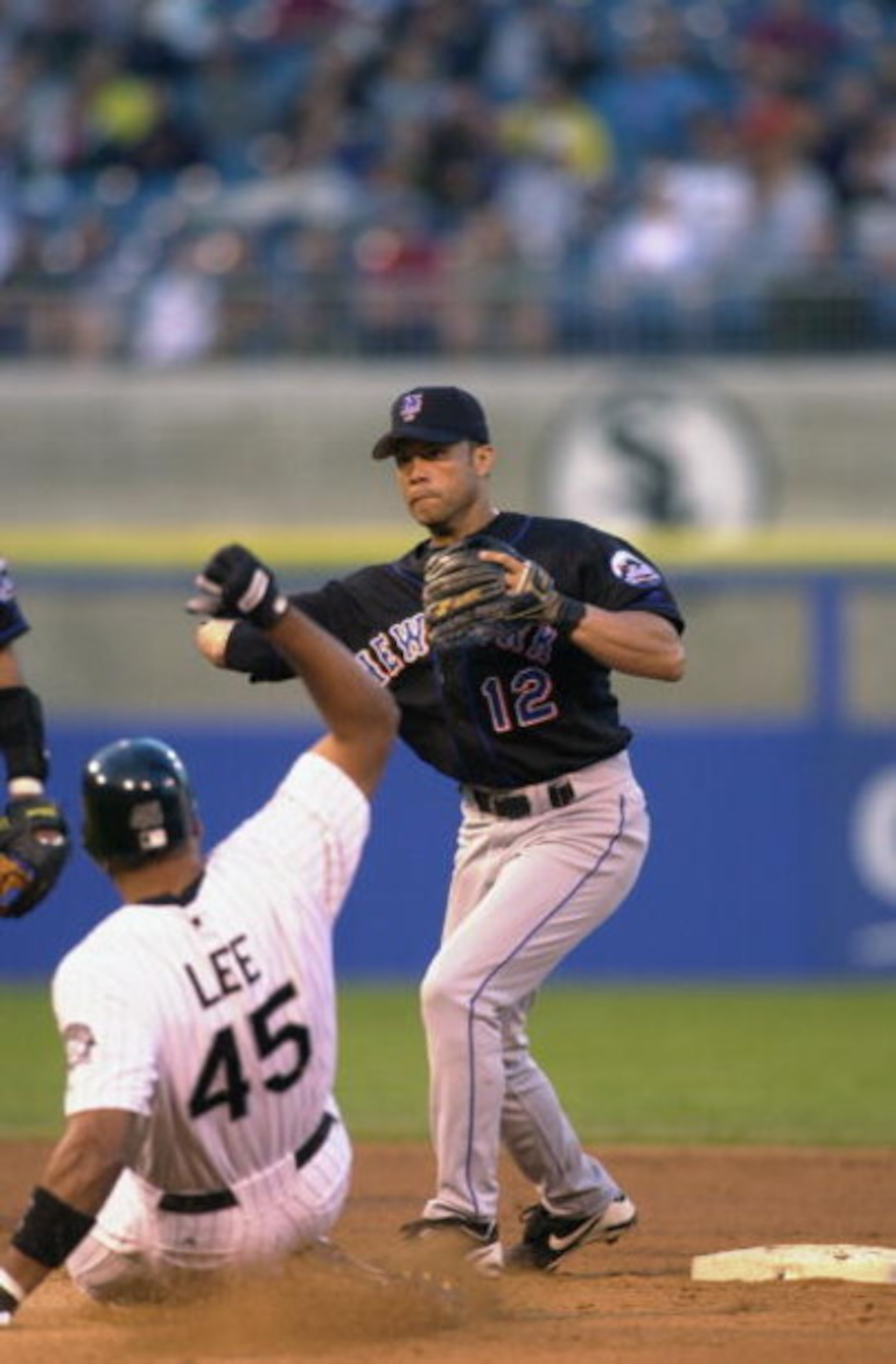 CHICAGO- JUNE 12:  Second baseman Roberto Alomar #12 of the N.Y. Mets completes a double play as outfielder Carlos Lee #45 of the Chicago White Sox slides on June 12, 2002 during their game at Comiskey Park in Chicago, Illinois.  (Photo by Jonathan Daniel