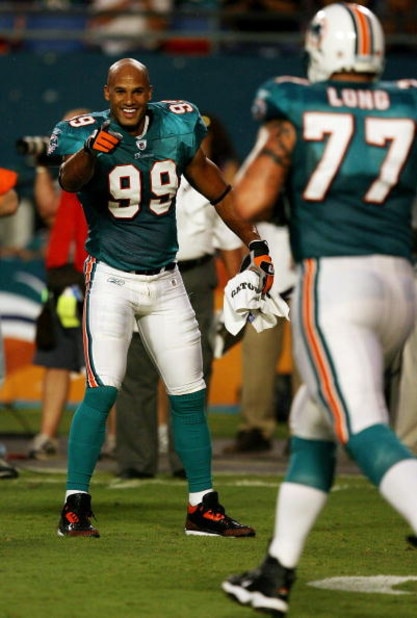 MIAMI - AUGUST 22:  Linebacker Jason Taylor #99 of the Miami Dolphins celebrates as he points to offensive lineman Jake Long #77 after a scoring drive against the Carolina Panthers during a pre-season game at Land Shark Stadium on August 22, 2009 in Miami