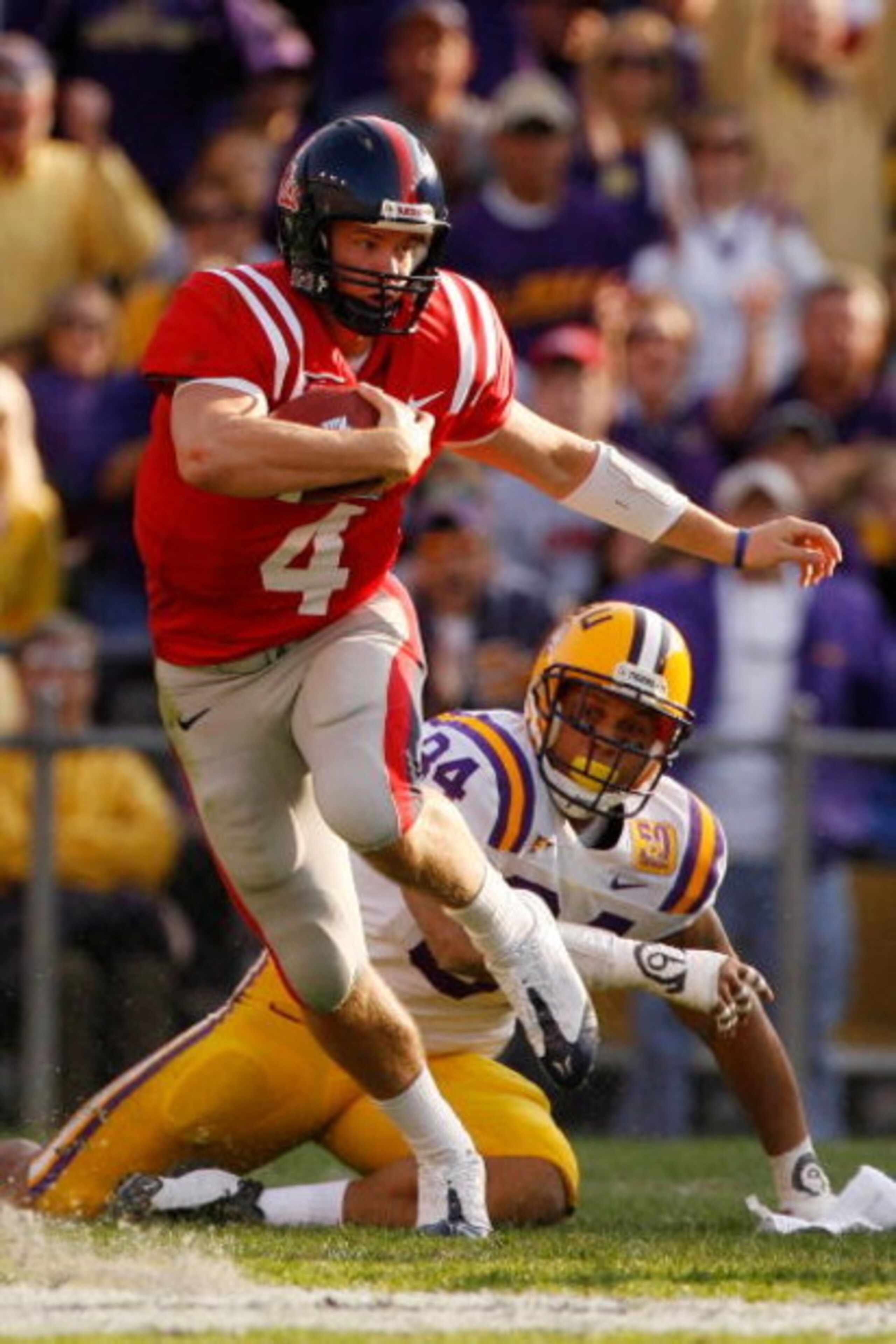 BATON ROUGE, LA - NOVEMBER 22:  Quarterback Jevan Snead #4 of the Ole Miss Rebels scrambles after a missed tackle by Rahim Alem #84 of the Louisiana State University Tigers  on November 22, 2008 at Tiger Stadium in Baton Rouge, Louisiana.  (Photo by Chris