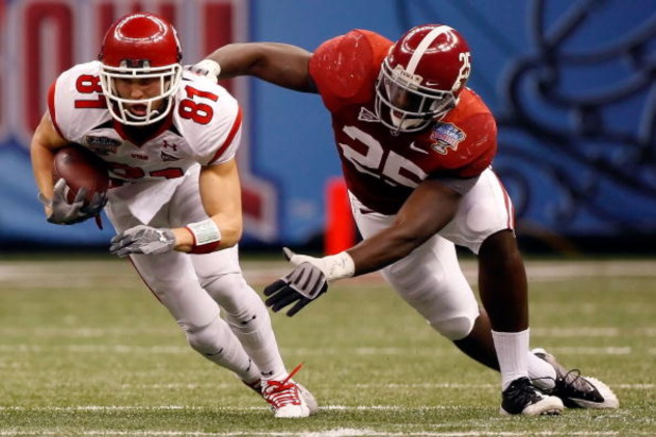 NEW ORLEANS - JANUARY 02:  Wide receiver Bradon Godfrey #81 of the Utah Utes runs after making a catch as he attempts to avoid a tackle by Rolando McClain #25 of the Alabama Crimson Tide in the first half during the 75th Allstate Sugar Bowl at the Louisia