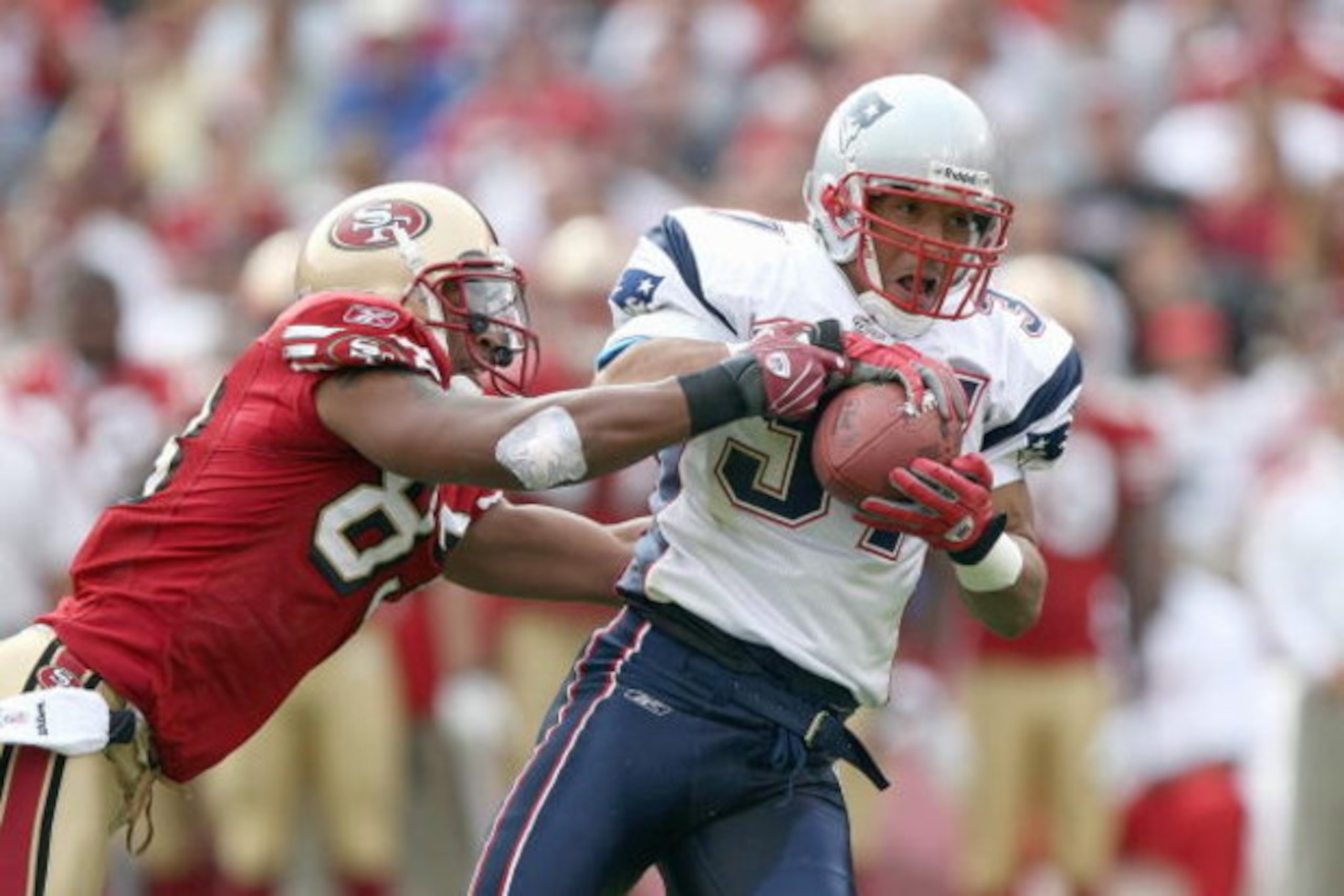 SAN FRANCISCO - OCTOBER 5:  Rodney Harrison #37 of the New England Patriots grips the ball as he is grabbed by Arnaz Battle #83 of the San Francisco 49ers during an NFL game on October 5, 2008 at Monster Park in San Francisco, California. 