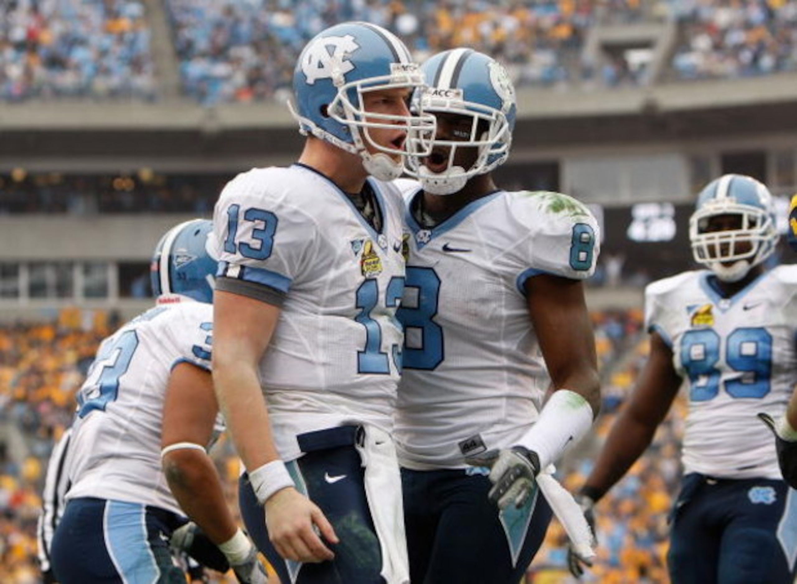 CHARLOTTE, NC - DECEMBER 27:  T.J. Yates #13 of the North Carolina Tar Heels celebrates with teammate Greg Little #8 after Yates scored a touchdown against the West Virginia Mountaineers during the Meineke Car Care Bowl on December 27, 2008 at Bank of Ame