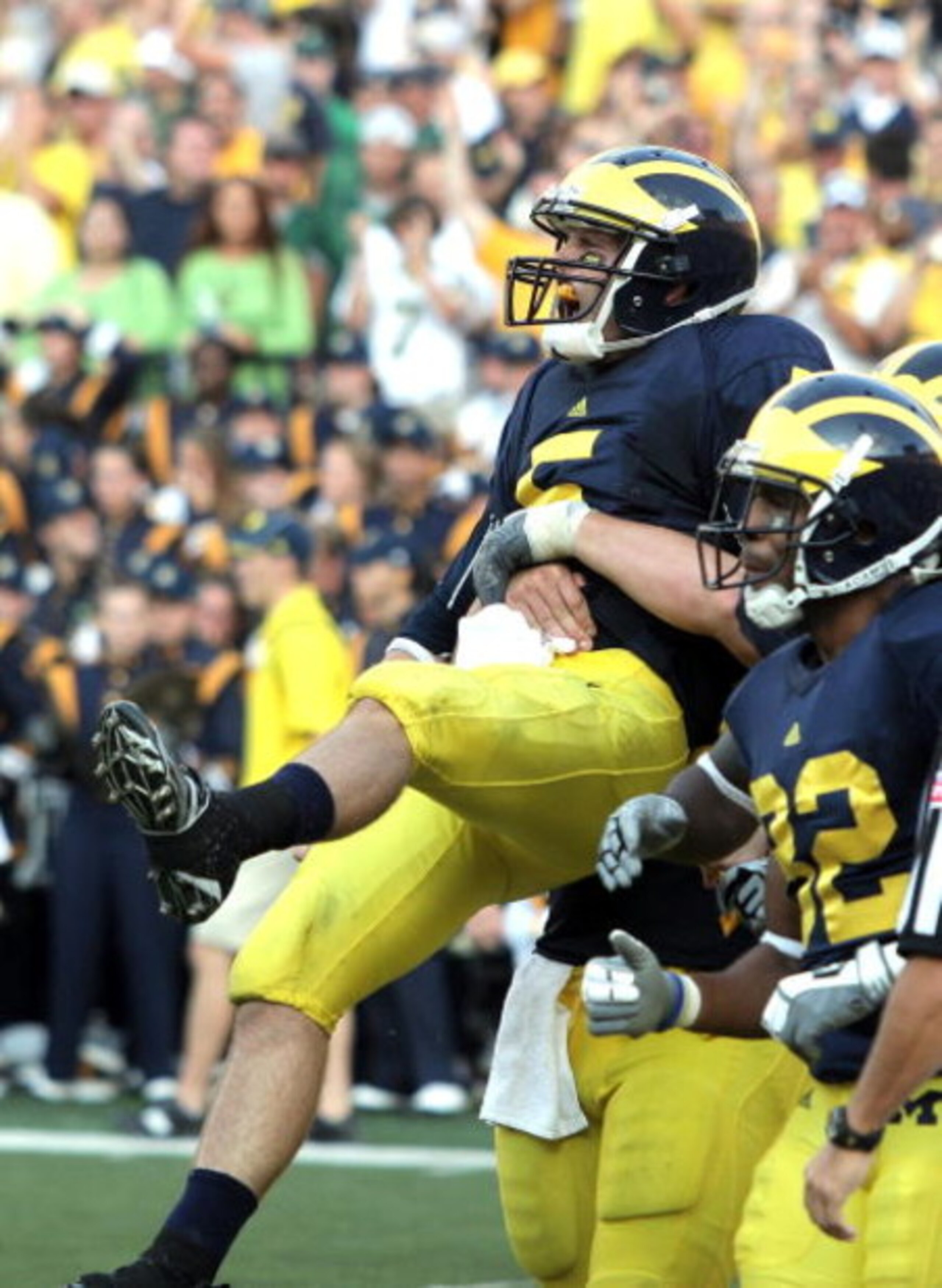 ANN ARBOR, MI - SEPTEMBER 12:  Quarterback Tate Forcier #5 of Michigan is hugged by a teammate after scoring a touchdown late in the game against Notre Dame at Michigan Stadium on September 12, 2009 in Ann Arbor, Michigan.  (Photo by Domenic Centofanti/Ge