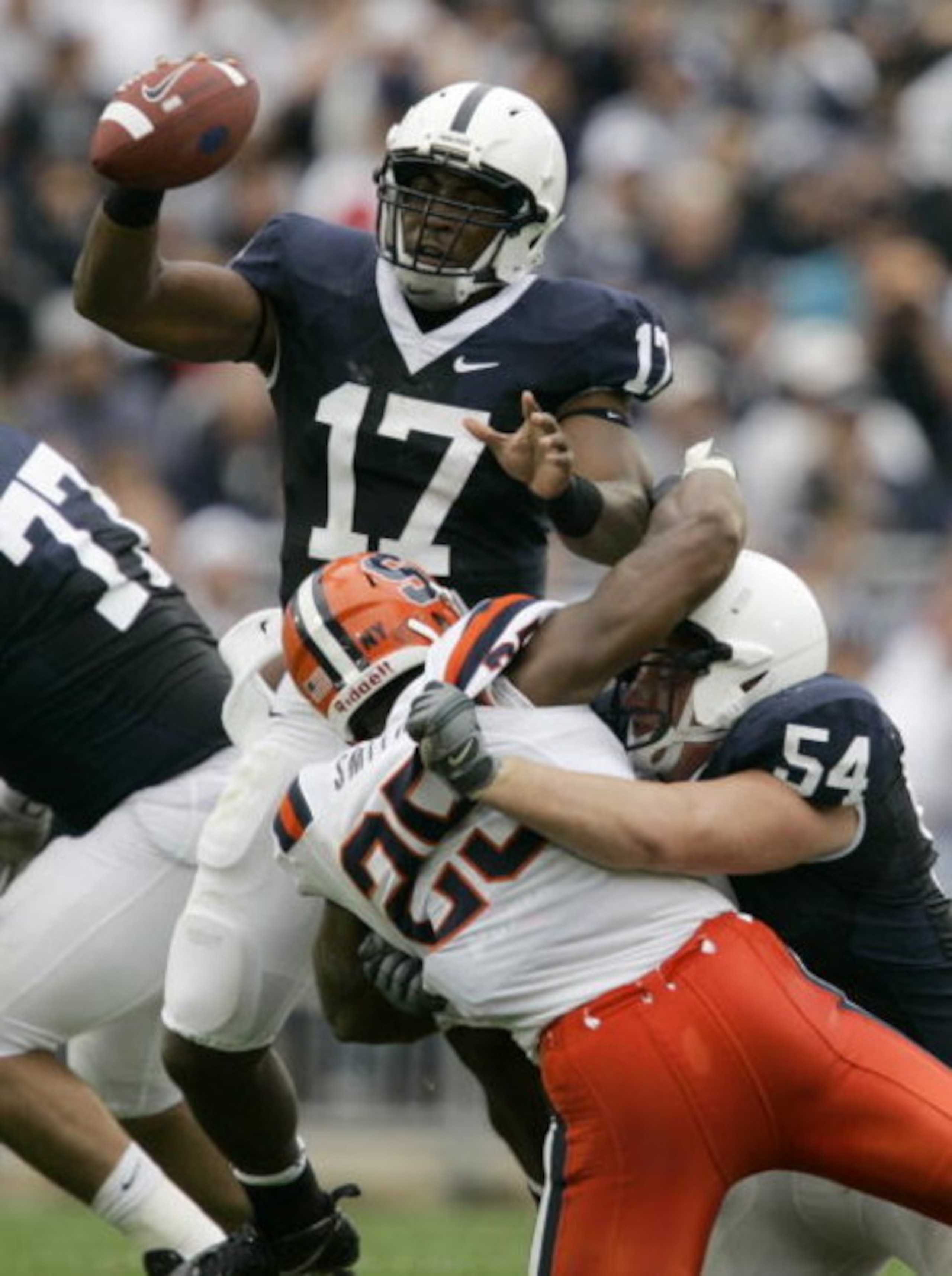 STATE COLLEGE, PA - SEPTEMBER 12: Quarterback Daryll Clark #17 of the Penn State Nittany Lions eludes a tackle by Nico Scott #28 of the Syracuse Orangemen as guard Matt Stankiewitch #54 of the Nittany Lions defends during the first half at Beaver Stadium 