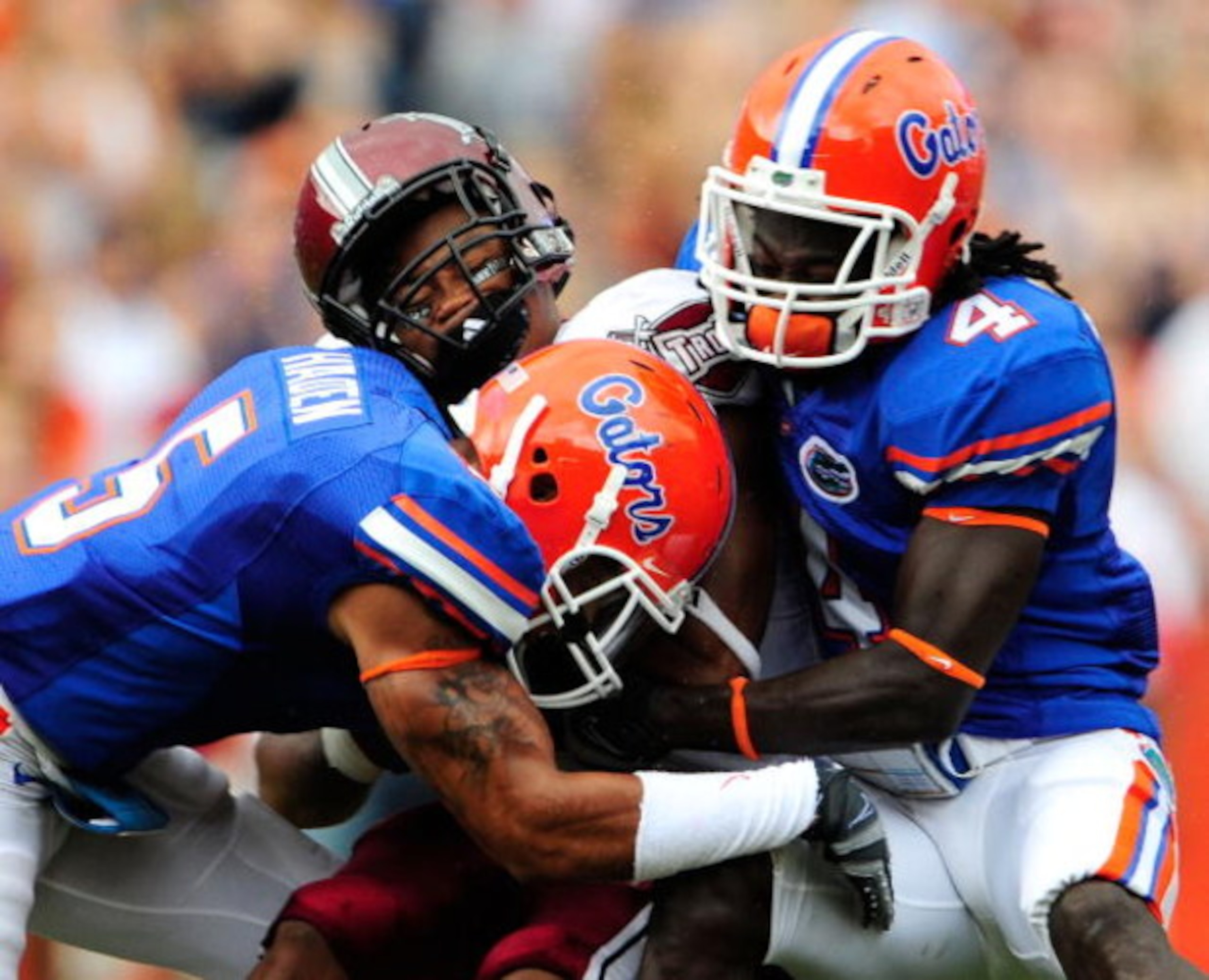 GAINESVILLE, FL - SEPTEMBER 12:  DuJuan Harris #32 of the Troy Trojans is tackled by Wondy Pierre-Louis #4 and Joe Haden #5 of the Florida Gators during the game at Ben Hill Griffin Stadium on September 12, 2009 in Gainesville, Florida.  (Photo by Sam Gre