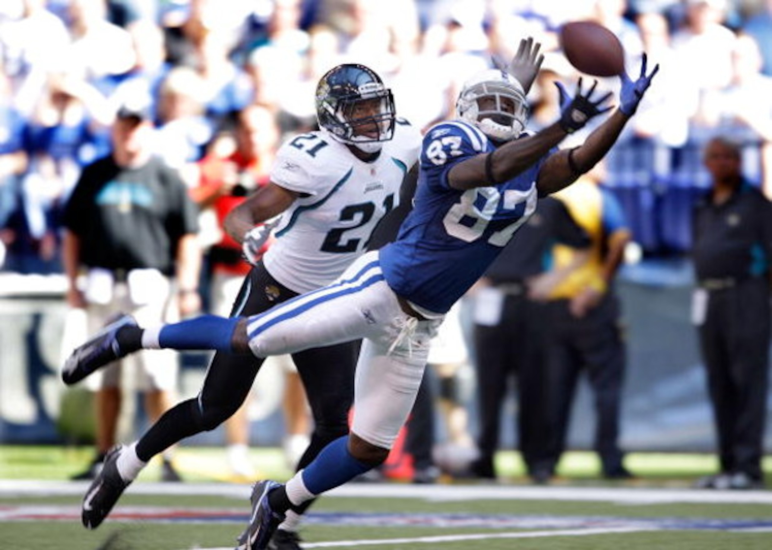 INDIANAPOLIS - SEPTEMBER 13:  Reggie Wayne #87 of the Indianapolis Colts reaches to catch a pass while defended by Derek Cox #21 of the Jacksonville Jaguars during the game at Lucas Oil Stadium on September 13, 2009 in Indianapolis, Indiana.  (Photo by An