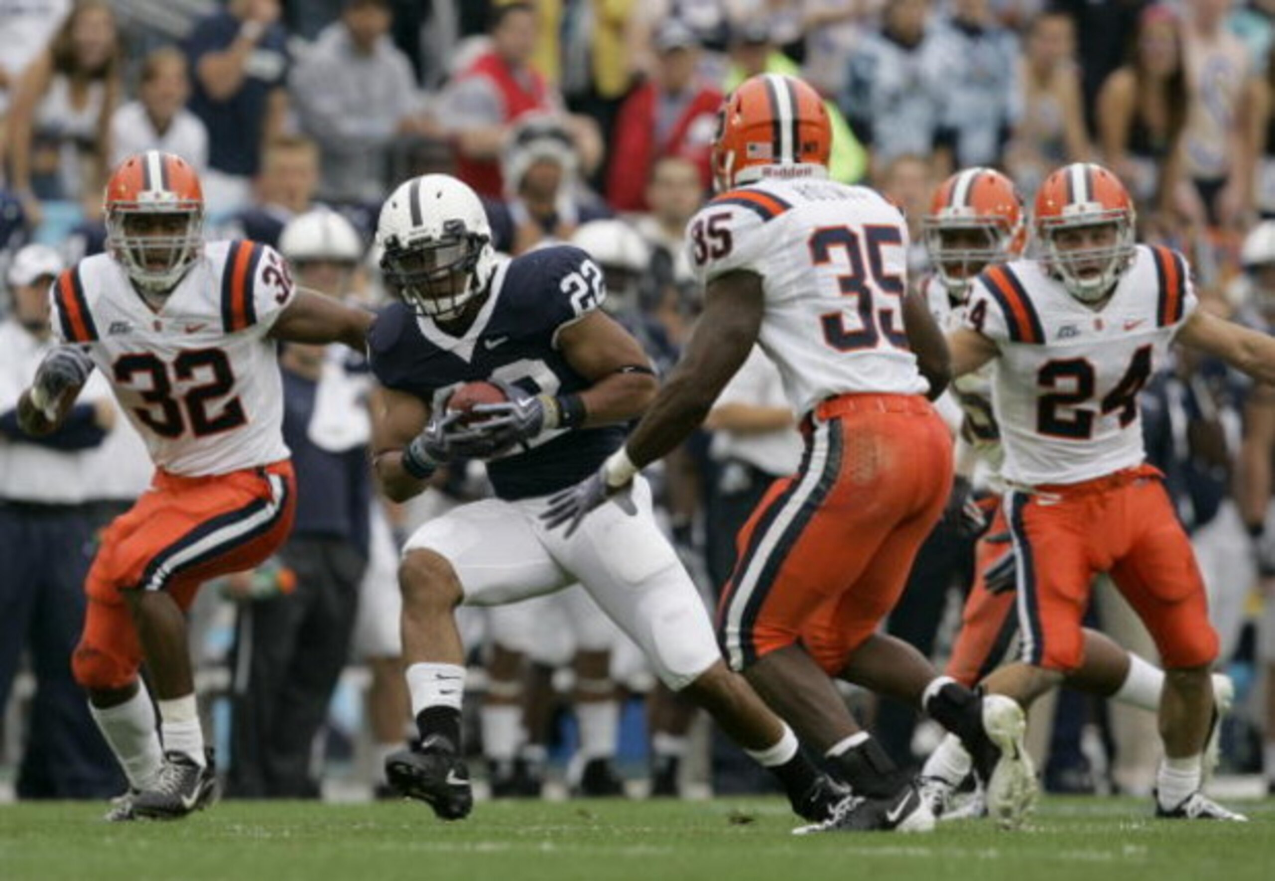 STATE COLLEGE, PA - SEPTEMBER 12: Tail back Evan Royster #22 of the Penn State Nittany Lions rushes through linebacker Doug Hogue #32 and safety Mike Holmes #35 of the Syracuse Orangemen during the first half at Beaver Stadium  September 12, 2009 in State