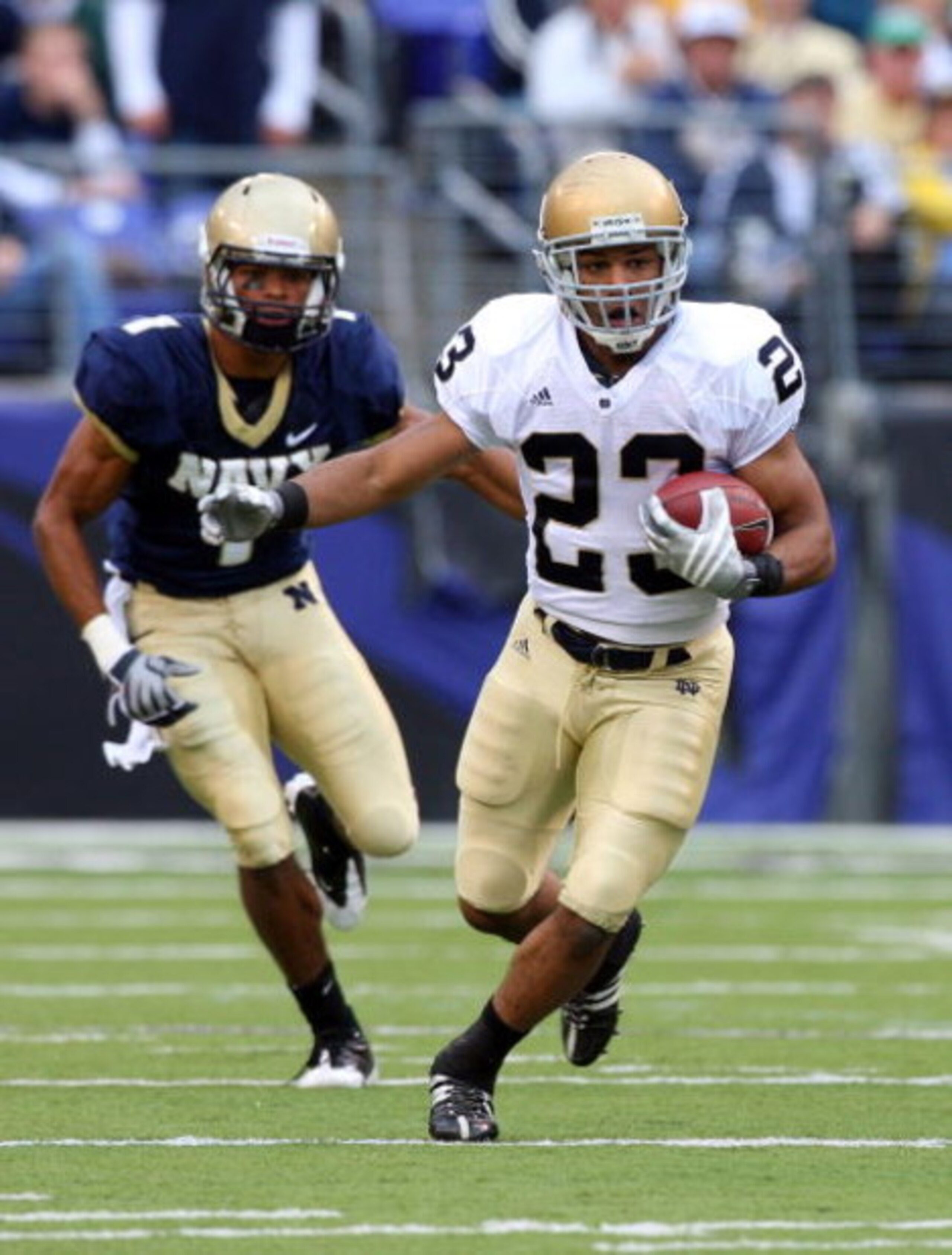 BALTIMORE - NOVEMBER 15:  Golden Tate #23 of the Notre Dame Fighting Irish runs the ball past Blake Carter #1 of the Navy Midshipmen on November 15, 2008 at M&T Bank Stadium in Baltimore, Maryland. Notre Dame defeated Navy 27-21.  (Photo by Jim McIsaac/Ge