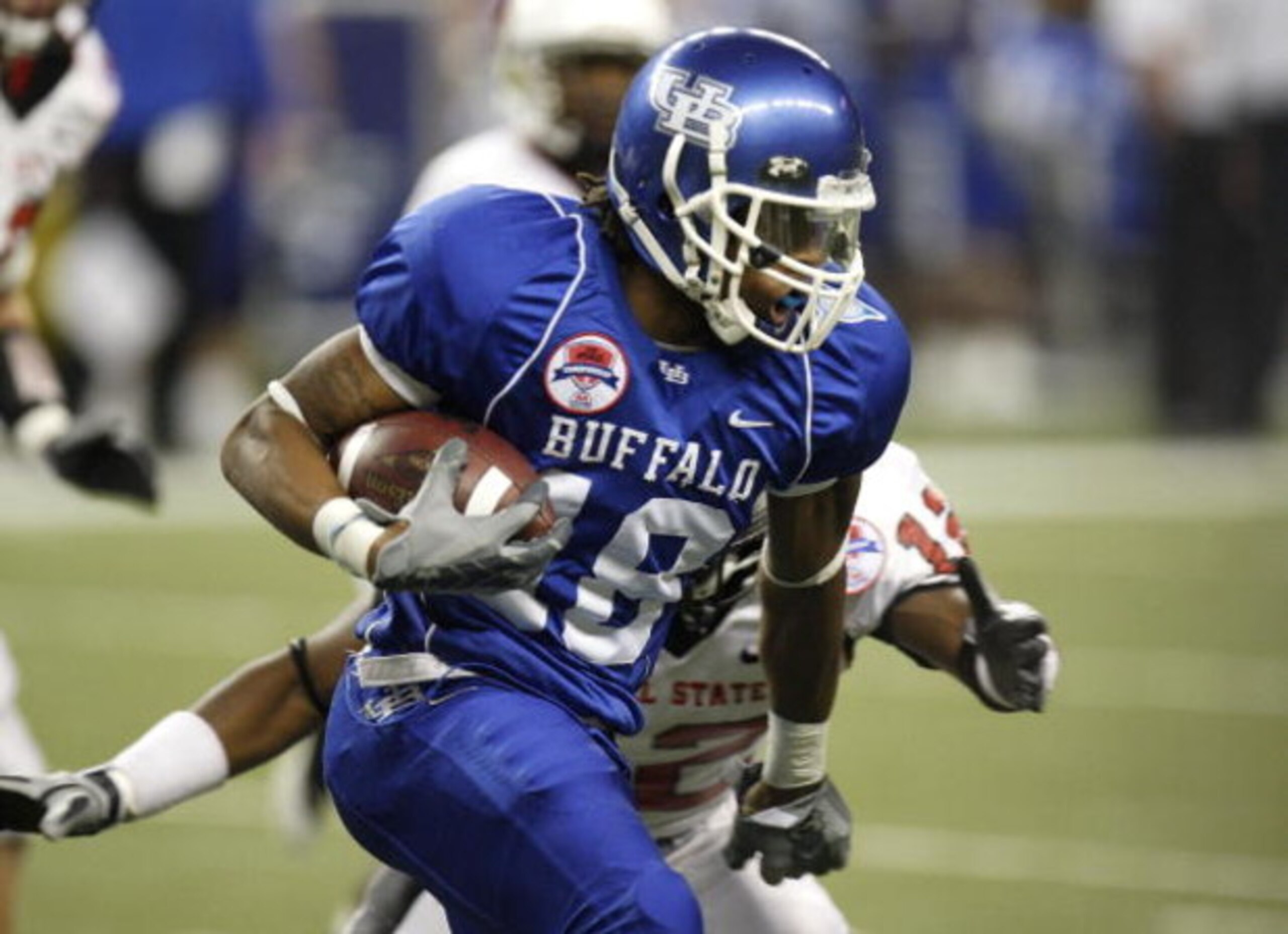 DETROIT - DECEMBER 05: Naaman Roosevelt #18 of the Buffalo Bulls tries to get around the tackle of Trey Lewis #12 of the Ball State Cardinals during the second quarter of the MAC Championship game on December 5, 2008 at Ford Field in Detroit, Michigan.  (