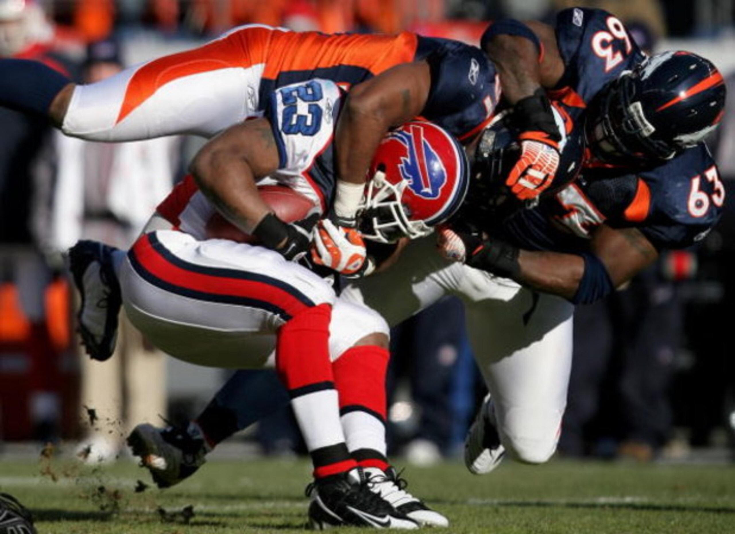 DENVER - DECEMBER 21:  Running back Marshawn Lynch #23 of the Buffalo Bills is tackled by Jamie Winborn #51 and Dewayne Robertson #63 of the Denver Broncos during NFL action at Invesco Field at Mile High on December 21, 2008 in Denver, Colorado. The Bills