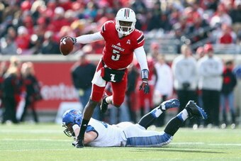 LOUISVILLE, KY - NOVEMBER 23:  Teddy Bridgewater #5 of the Louisville Cardinals avoids the tackle of Chase Rome #47 of the Memphis Tigers at Papa John's Cardinal Stadium on November 23, 2013 in Louisville, Kentucky.  (Photo by Andy Lyons/Getty Images)