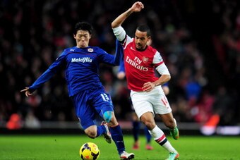 LONDON, ENGLAND - JANUARY 01:  Theo Walcott of Arsenal takes on Kim Bo-Kyung of Cardiff City during the Barclays Premier League match between Arsenal and Cardiff City at Emirates Stadium on January 1, 2014 in London, England.  (Photo by Shaun Botterill/Ge