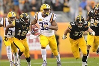 Jan 1, 2014; Tampa, Fl, USA; LSU Tigers running back Jeremy Hill (33) runs past Iowa Hawkeyes defensive back John Lowdermilk (37) during the first half at Raymond James Stadium. Mandatory Credit: Steve Mitchell-USA TODAY Sports