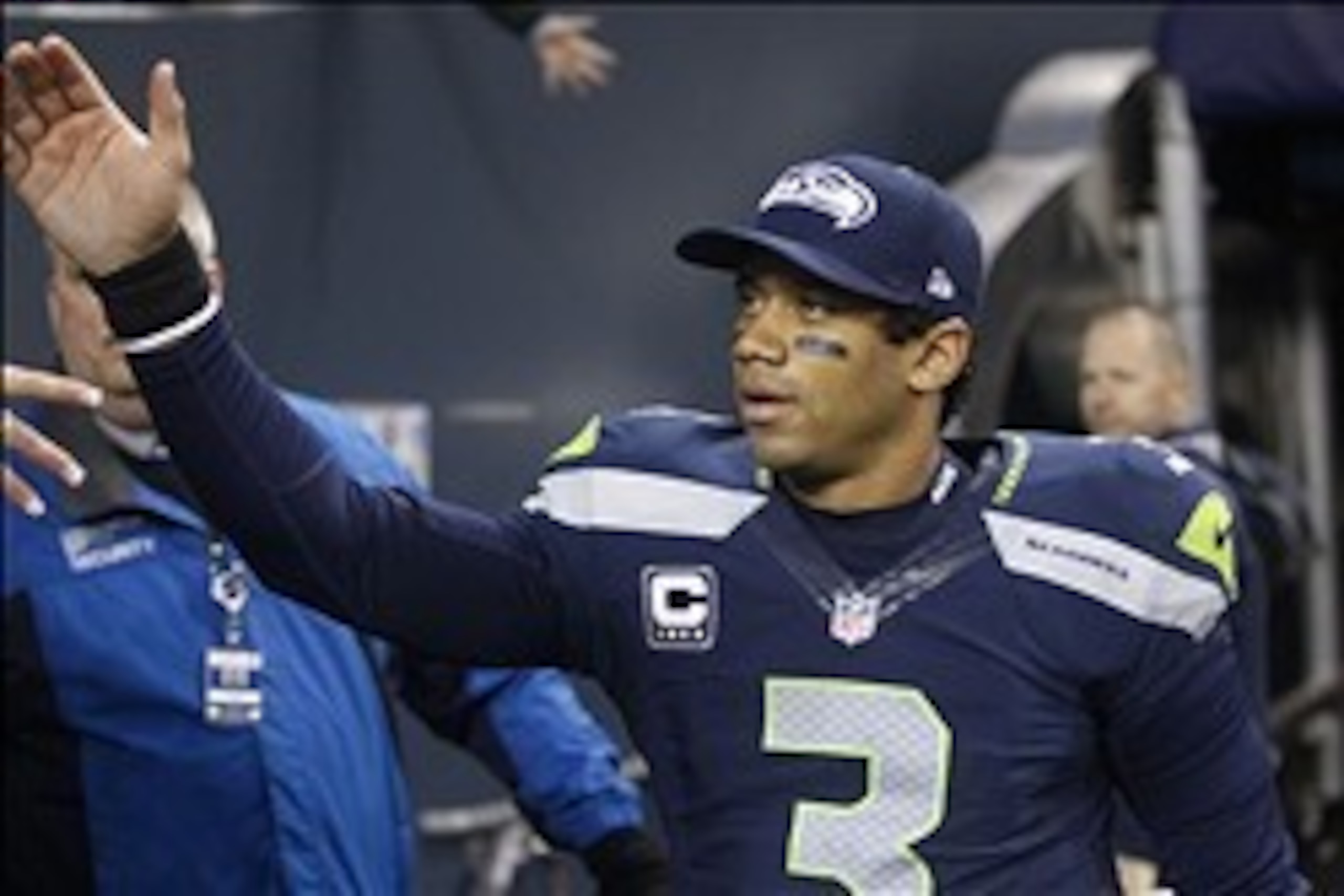 Dec 29, 2013; Seattle, WA, USA; Seattle Seahawks quarterback Russell Wilson (3) high-fives fans following a 29-7 victory against the St. Louis Rams at CenturyLink Field. Mandatory Credit: Joe Nicholson-USA TODAY Sports