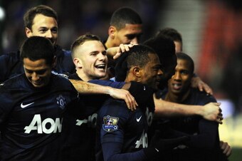 STOKE ON TRENT, ENGLAND - DECEMBER 18:  Patrice Evra of Manchester United celebrates scoring his team's second goal with his team-mates during the Capital One Cup Quarter Final match between Stoke City and Manchester United at the Britannia Stadium on Dec