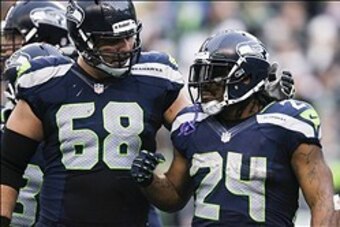 Dec 29, 2013; Seattle, WA, USA; Seattle Seahawks running back Marshawn Lynch (24) celebrates a touchdown run with Seattle Seahawks tackle Breno Giacomini (68) during the third quarter at CenturyLink Field. Mandatory Credit: Joe Nicholson-USA TODAY Sports