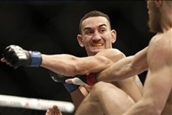 Aug 17, 2013; Boston, MA, USA; Max Holloway (left) throws a punch at Conor McGregor (right) during a UFC featherweight match at the TD Garden. McGregor won after three rounds by judges decision. Mandatory Credit: Winslow Townson-USA TODAY Sports